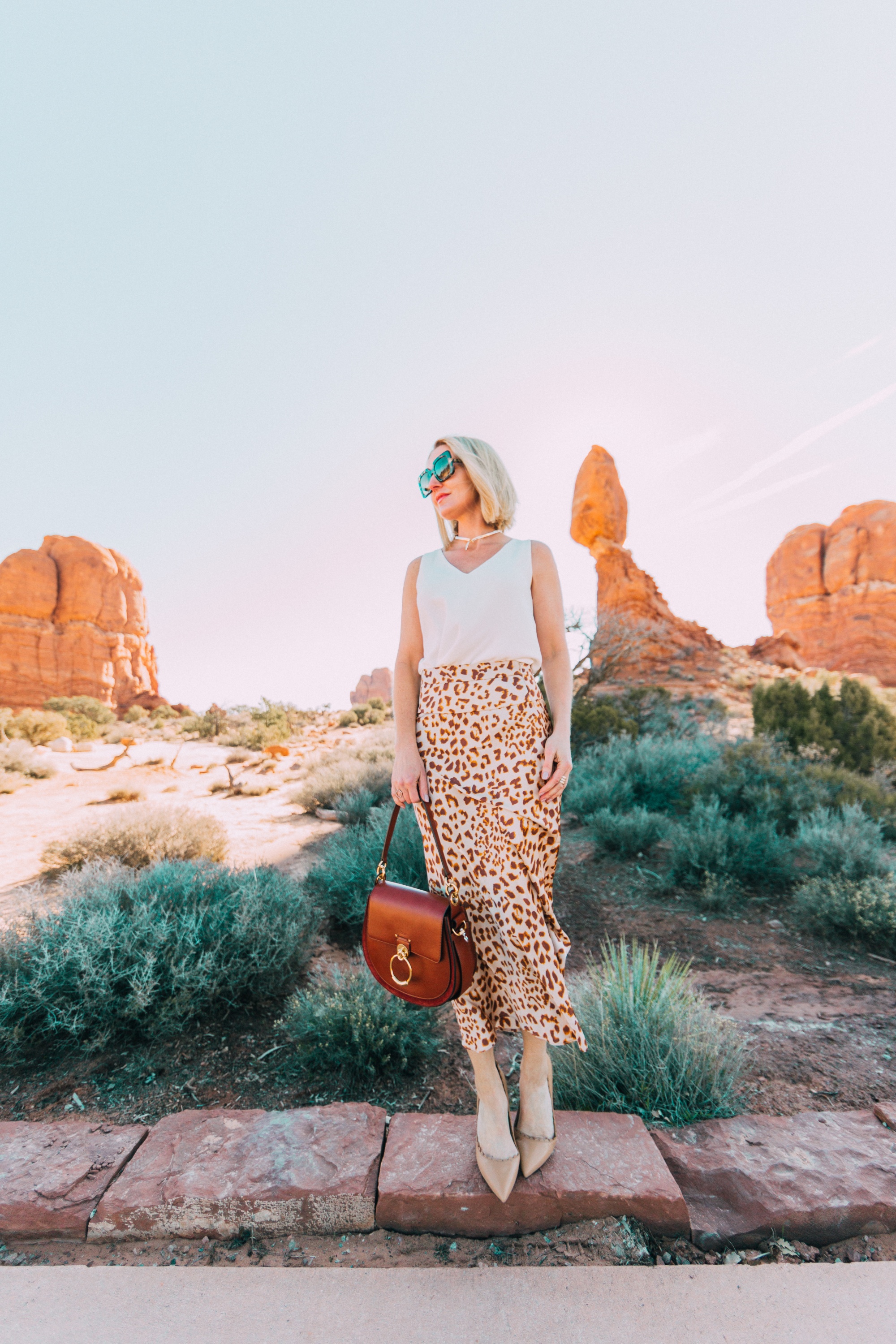 How To Wear Animal Prints, Fashion blogger Erin Busbee of BusbeeStyle.com wearing a white AQUA tank from bloomingdale's with a leopard print midi skirt by Free People in Moab, Utah