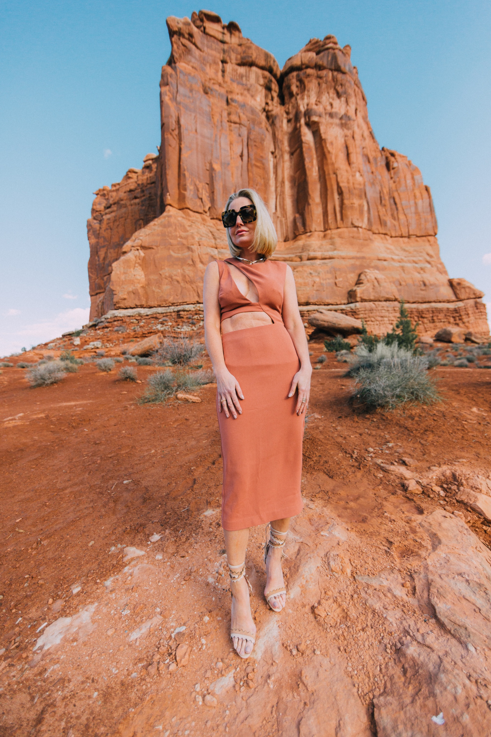 Vacation Dresses, Fashion blogger over 40 Erin Busbee of BusbeeStyle.com wearing a rusty pink cutout dress by NBD from Revolve with Schutz strappy sandals in Moab, Utah