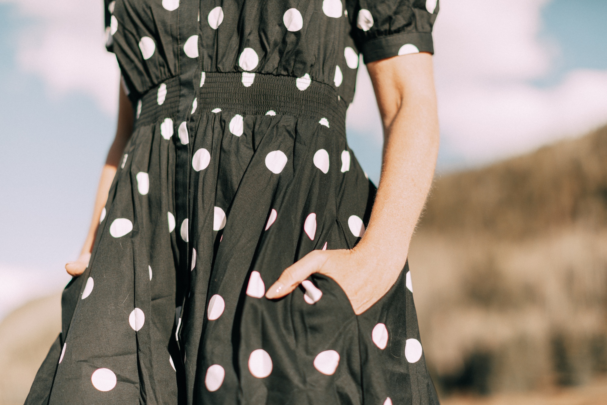 Affordable Summer Dresses, Fashion blogger Erin Busbee of BusbeeStyle.com wearing a black and white polka dot dress by Worthington from JCPenney with white Liz Claiborne sling back mules in Telluride, CO