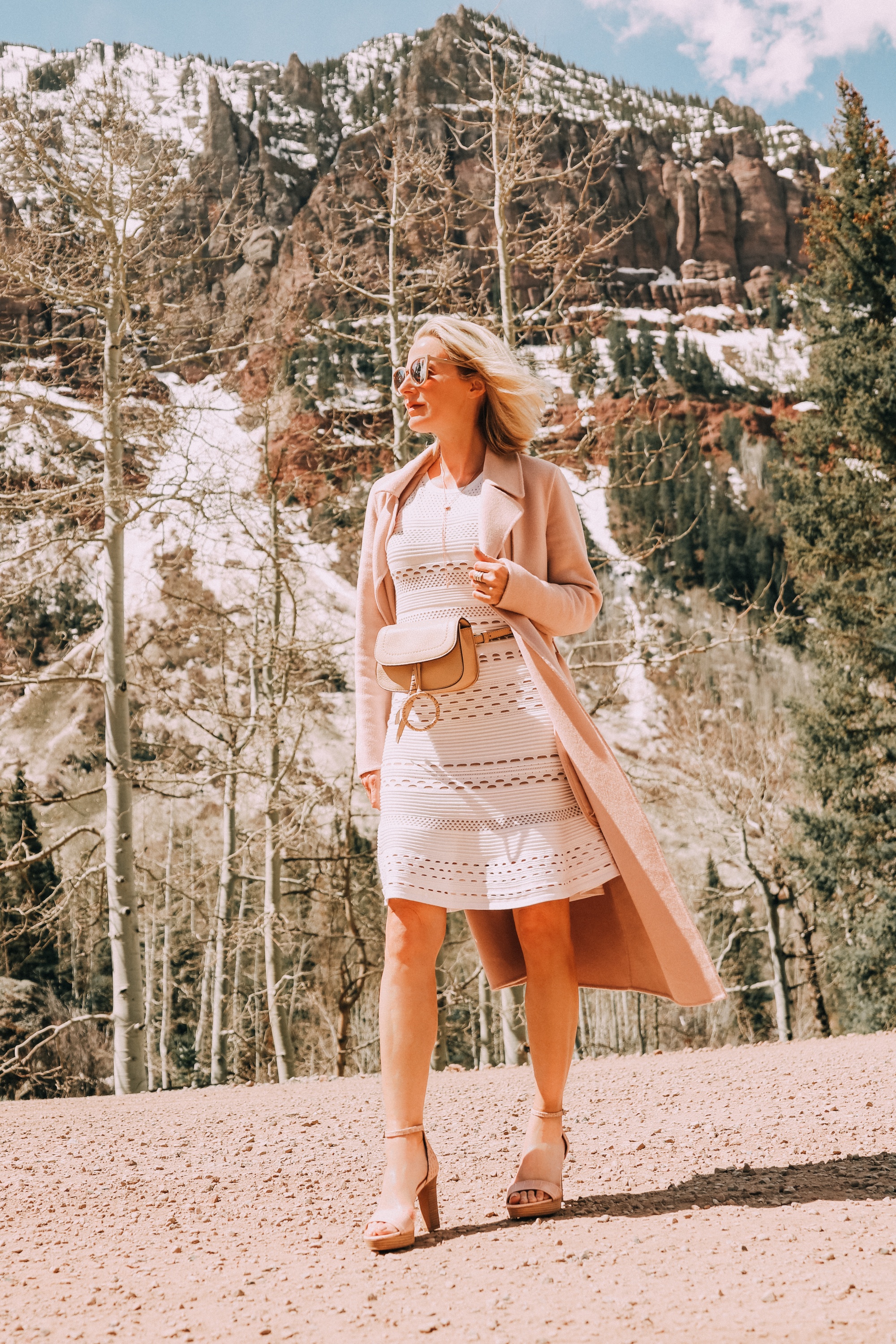 Neutral Accessories, Fashion blogger Erin Busbee of BusbeeStyle.com featuring a beige belt bag, neutral platform sandals, and a lariat necklace by Vince Camuto and wearing a Bailey 44 white dress and blush coat in Telluride, CO