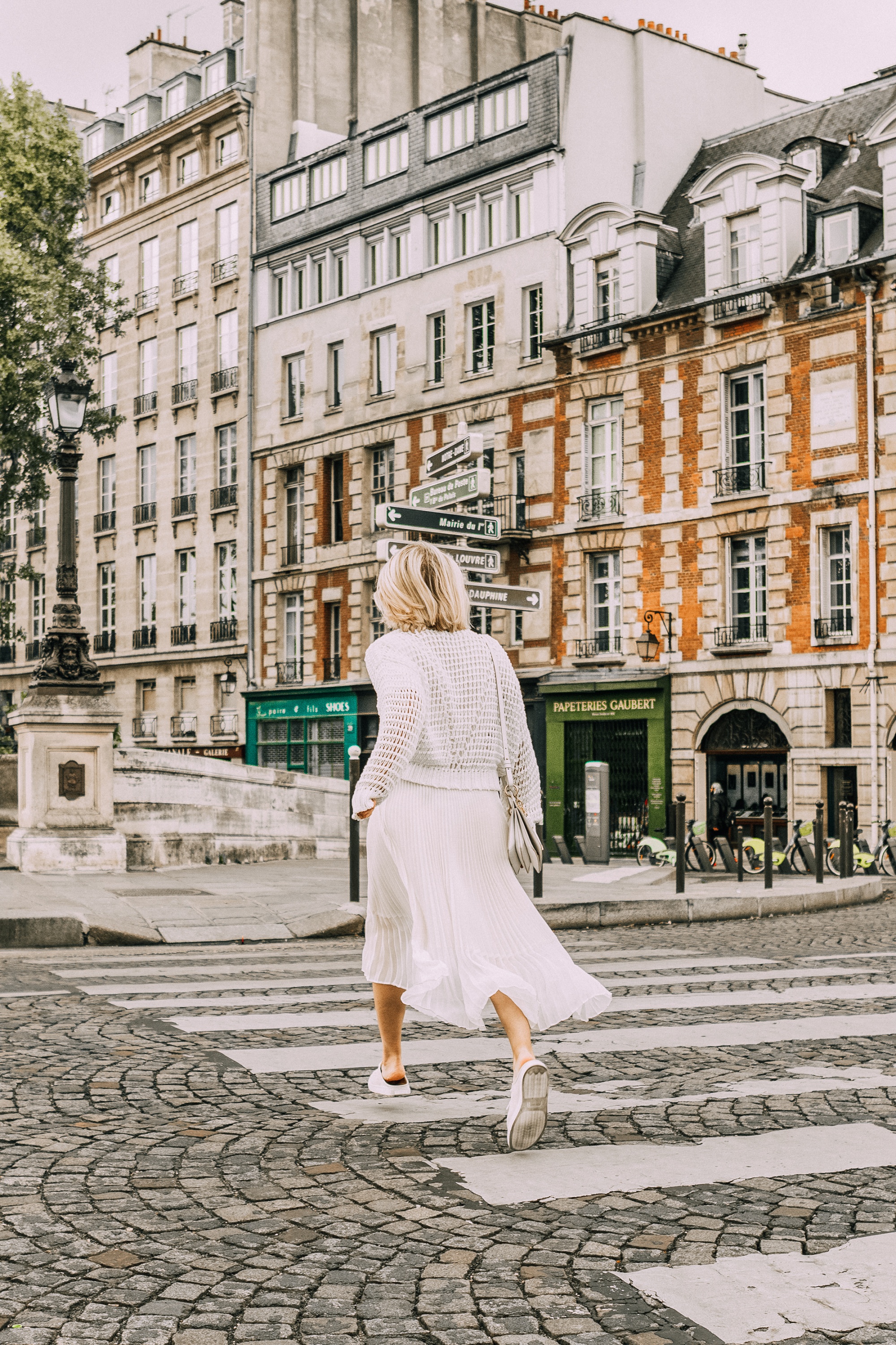 Best Travel Shoes, Fashion blogger Erin Busbee of BusbeeStyle.com wearing sneaker mules and pleated skirt by Club Monaco with a waffle knit sweater from Nordstrom in Paris, France