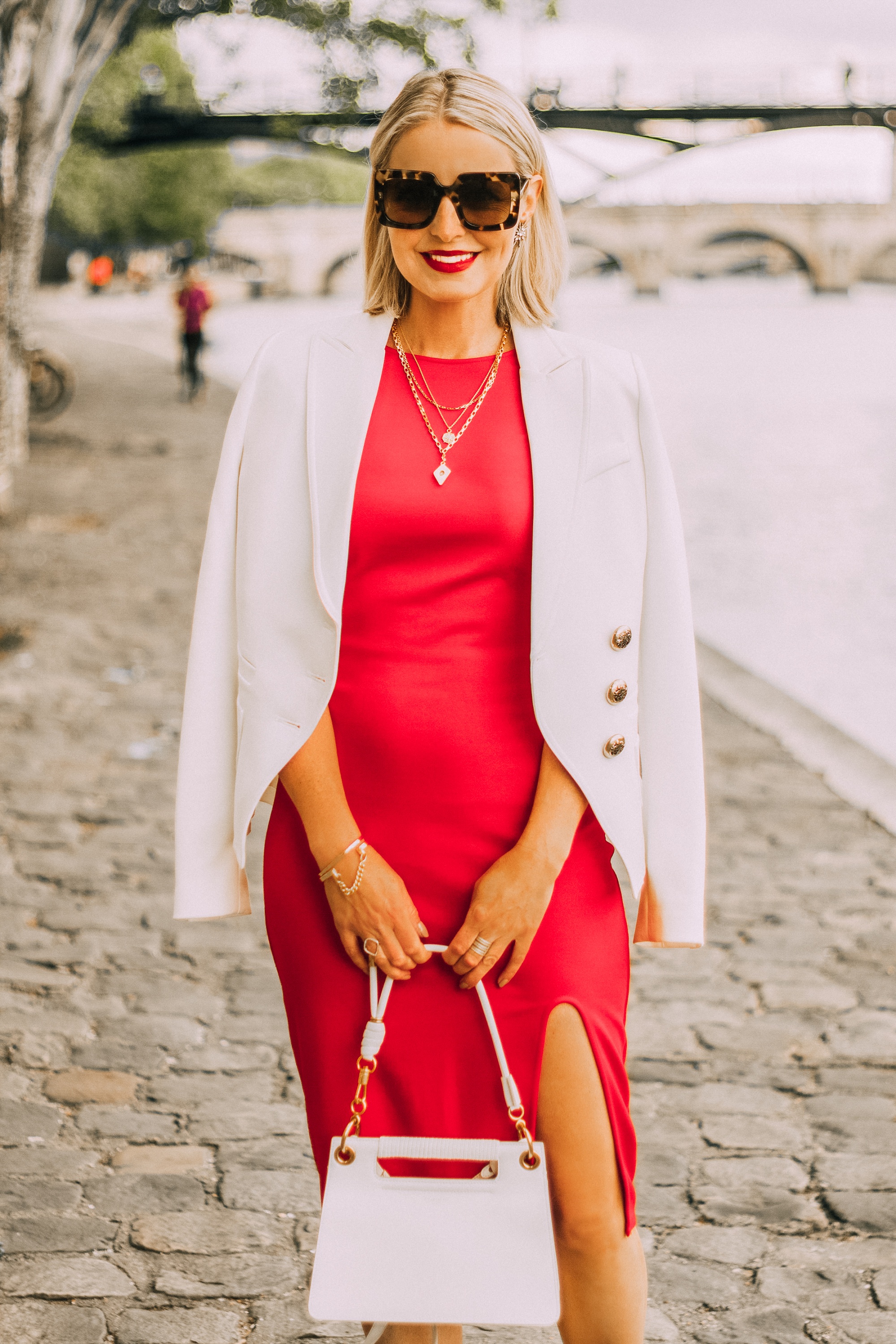 fashion blogger wearing red date night dress ivory smythe wrap blazer draped over shoulders carrying white calfskin givenchy whip bag in paris france 