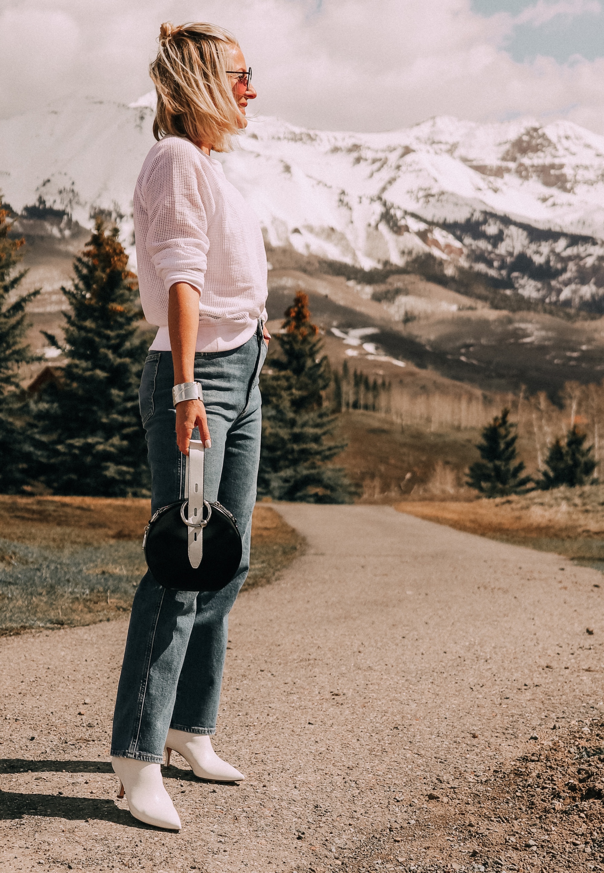 fashion blogger wearing white eileen fisher open knit raglan sweater with agolde pinch waist kick flare jeans stuart weitzman juniper 70 leather pointed toe booties carrying rebecca minkoff kate colorblock circle bag