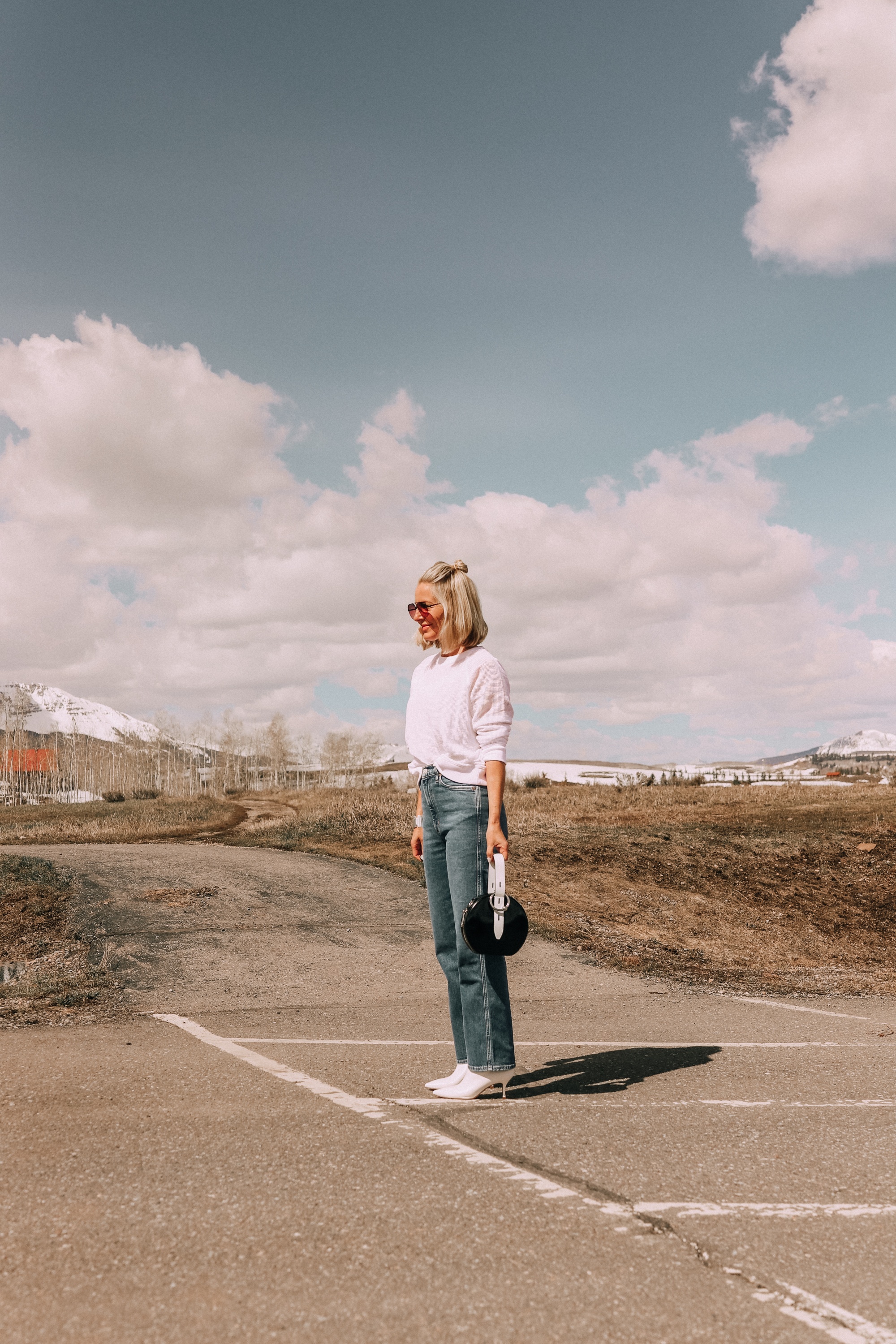 fashion blogger wearing white eileen fisher open knit raglan sweater with agolde pinch waist kick flare jeans stuart weitzman juniper 70 leather pointed toe booties