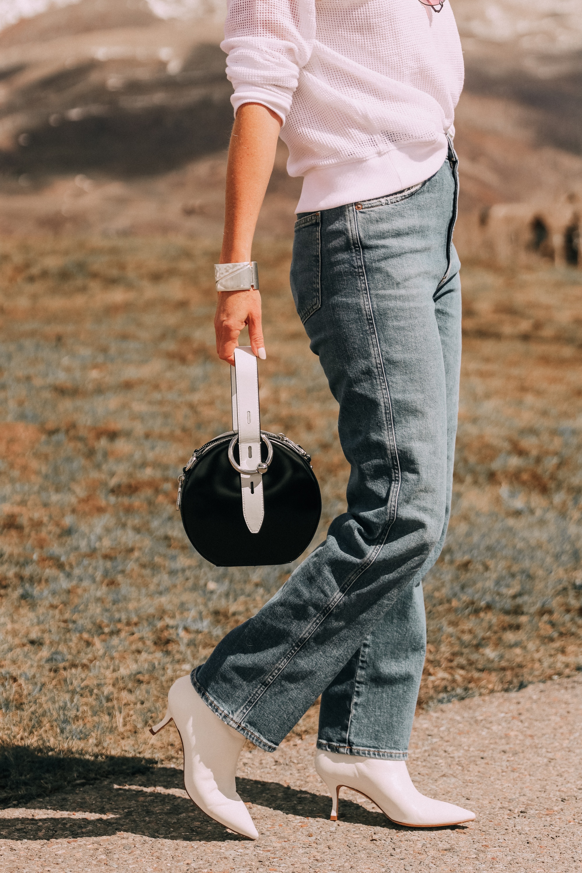 agolde pinch waist kick flare jeans paired with stuart weitzman juniper 70 leather pointed toe booties white eileen fisher open knit raglan sweater