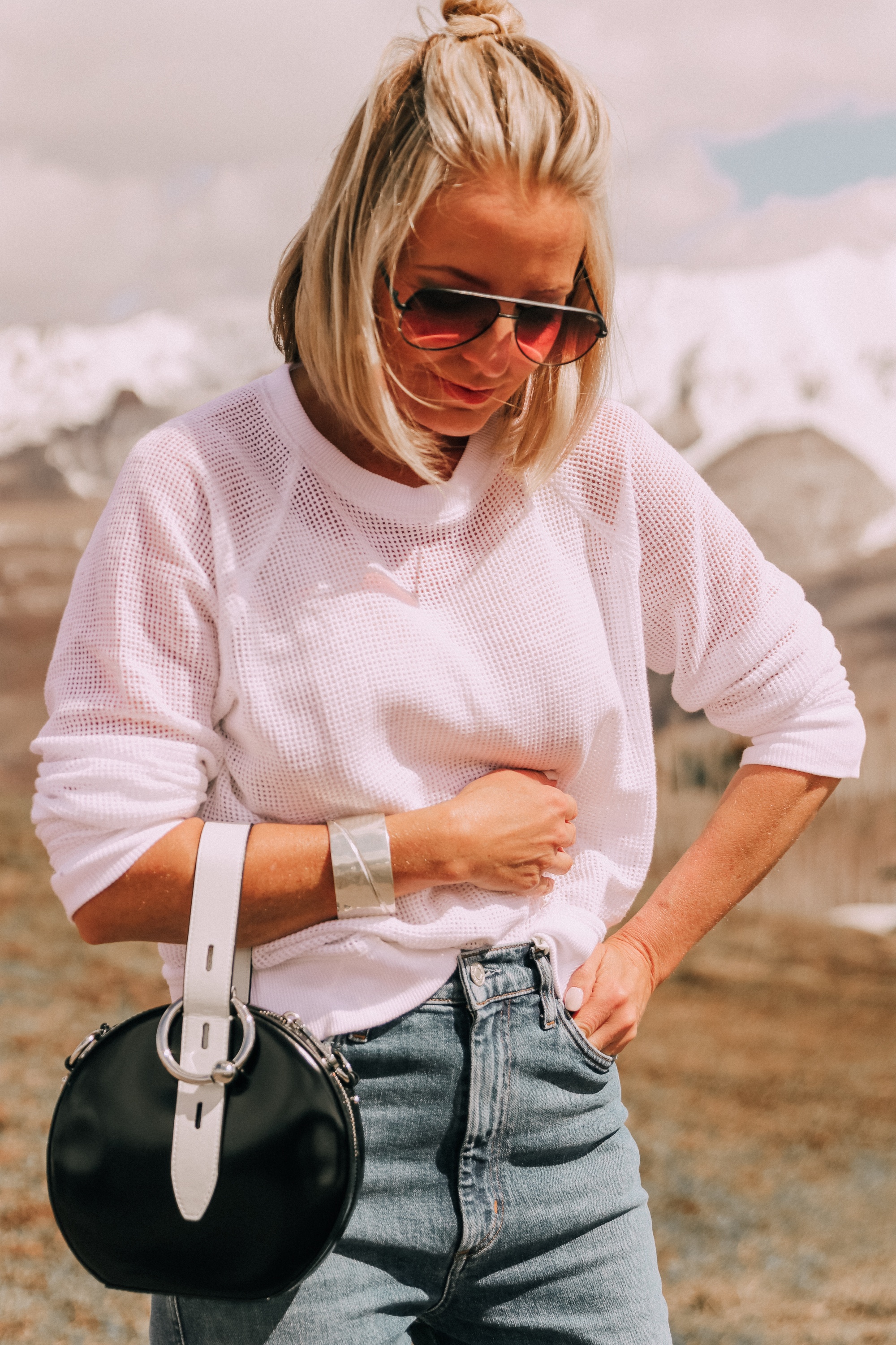 wearing white eileen fisher open knit raglan sweater with agolde pinch waist kick flare jeans