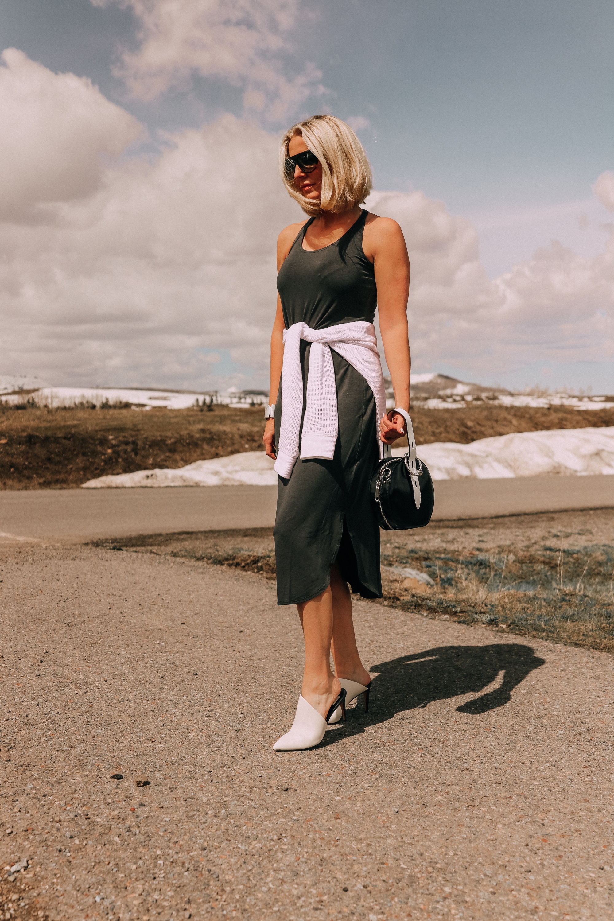 fashion blogger wearing eileen fisher midi tank dress with raglan sweater tied around waist paired with dolce vita camala high-heel mules