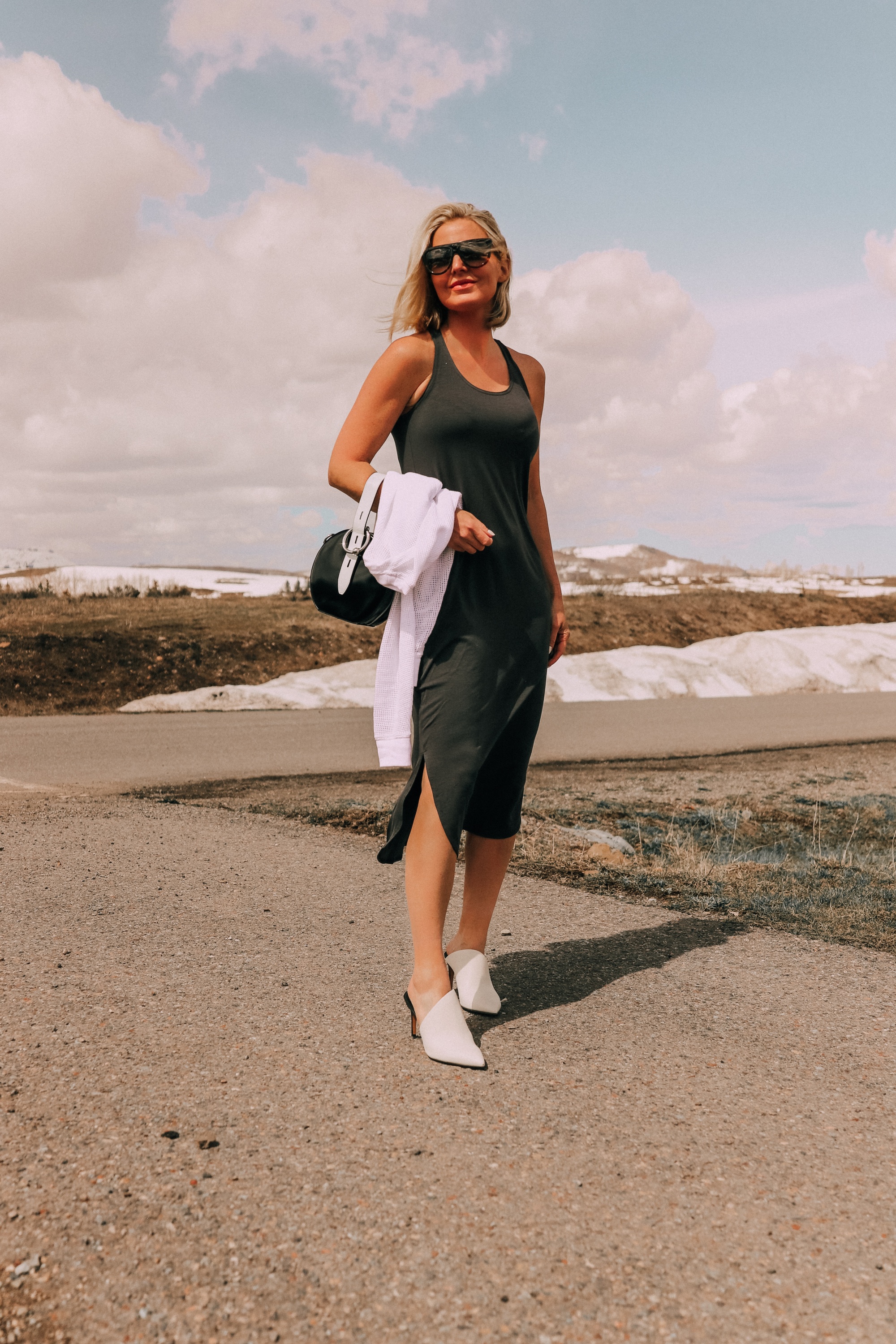 fashion blogger wearing eileen fisher racerback midi tank dress carrying raglan sweater paired with dolce vita camala high-heel mules