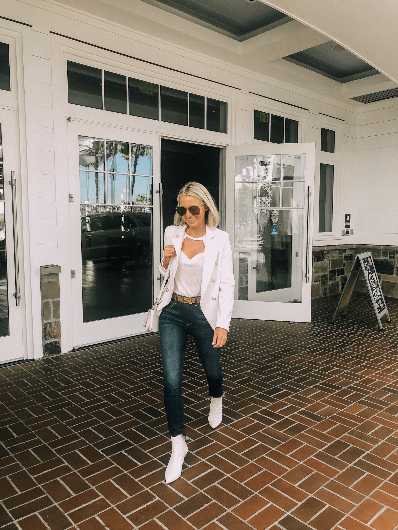 How To Pack Light, Fashion blogger Busbee Style wearing white blazer, white tee, rag and bone jeans, white stuart weitzmab booties in Newport Beach, California