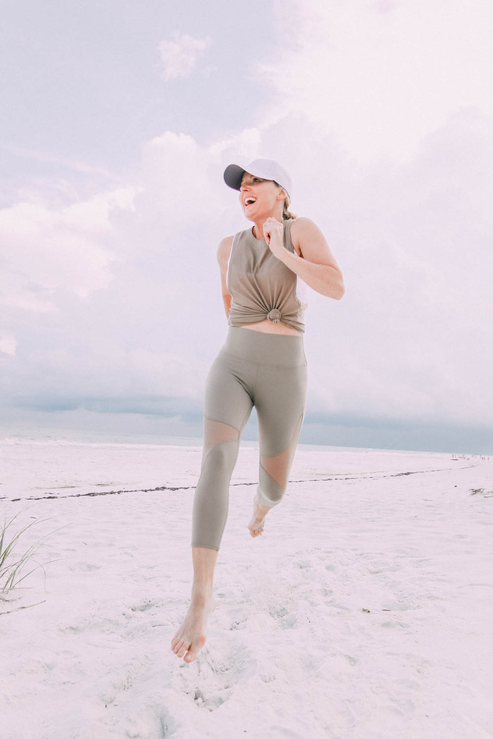 Fashion blogger Erin Busbee wearing tan leggings and tank by Alo Yoga on the beach in Florida