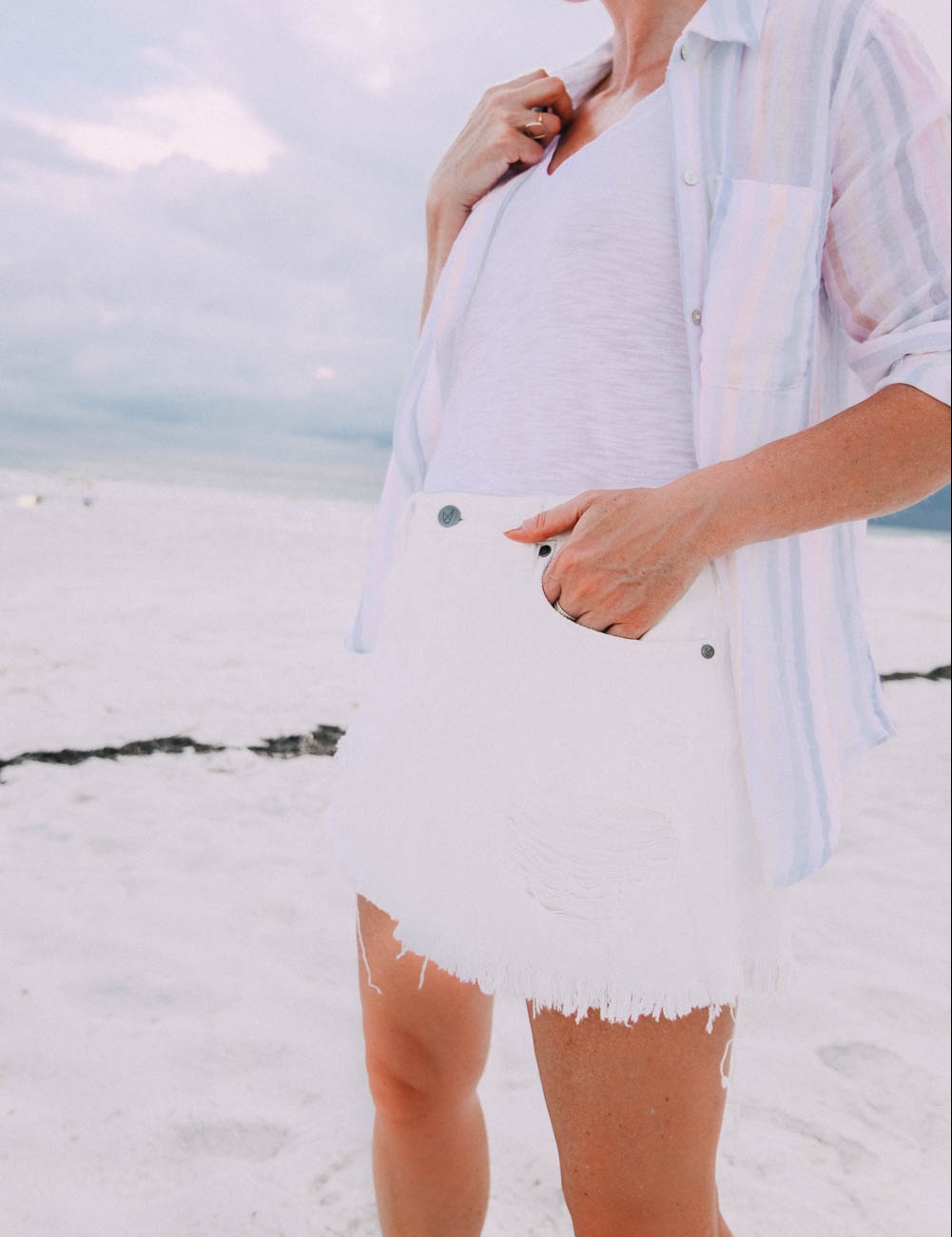 Skorts, Fashion blogger Erin Busbee of BusbeeStyle.com wearing a white denim skort fro Revolve with a Madewell tee and Rails striped button down on the beach in Florida