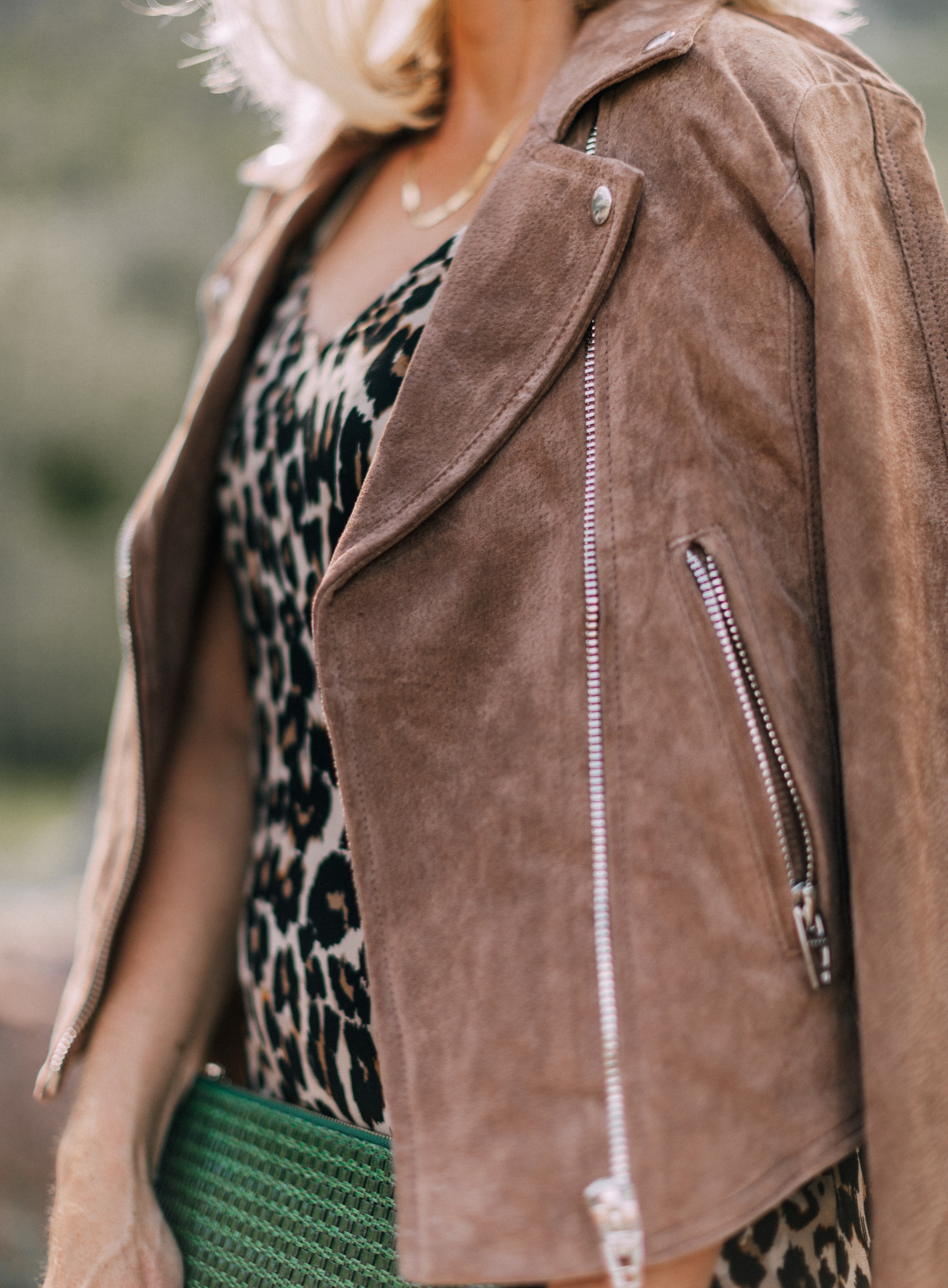 Styling animal print clothes with neutral Accessories, Fashion blogger Erin Busbee of BusbeeStyle,com wearing leopard print slip dress, blanknyc tan suede moto jacket, tan suede peep-toe mules and a green woven clutch by Vince Camuto in Telluride, CO