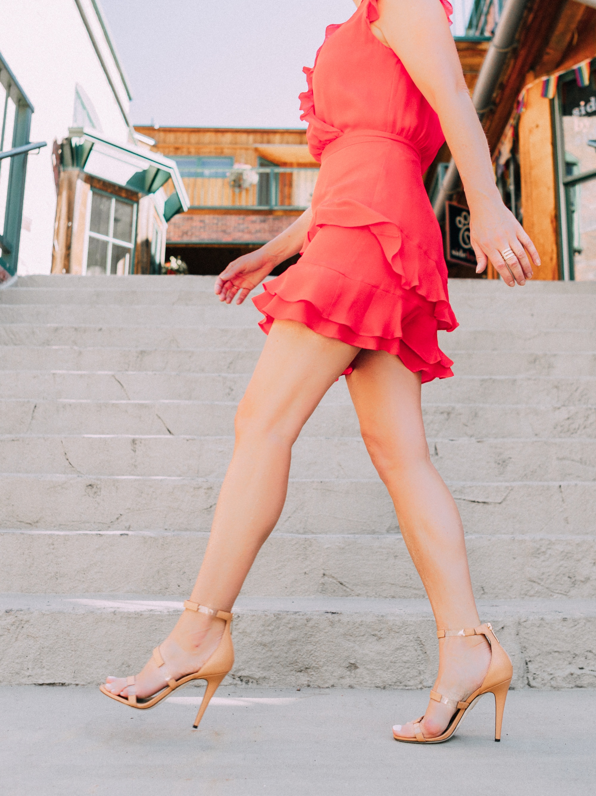 Tamara Mellon, Fashion blogger Erin Busbee of BusbeeStyle.com wearing a red ruffle dress with stunning Tamara Mellon Frontline heels in Telluride, Colorado, transparent sandals