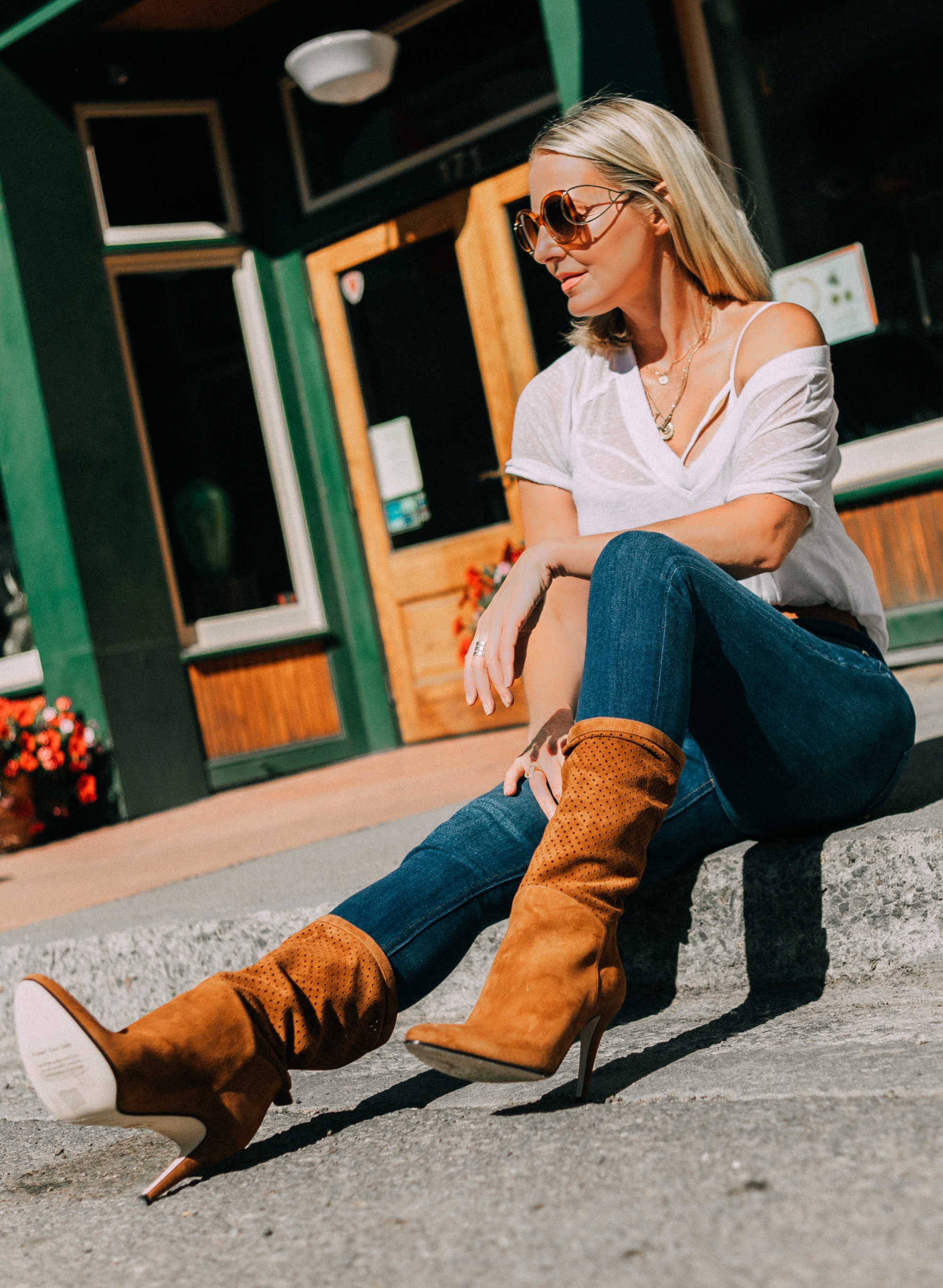 Tamara Mellon, Fashion blogger Erin Busbee of BusbeeStyle.com wearing dark was skinny jeans and white tee with stunning Tamara Mellon perforated brown boots in Telluride, Colorado