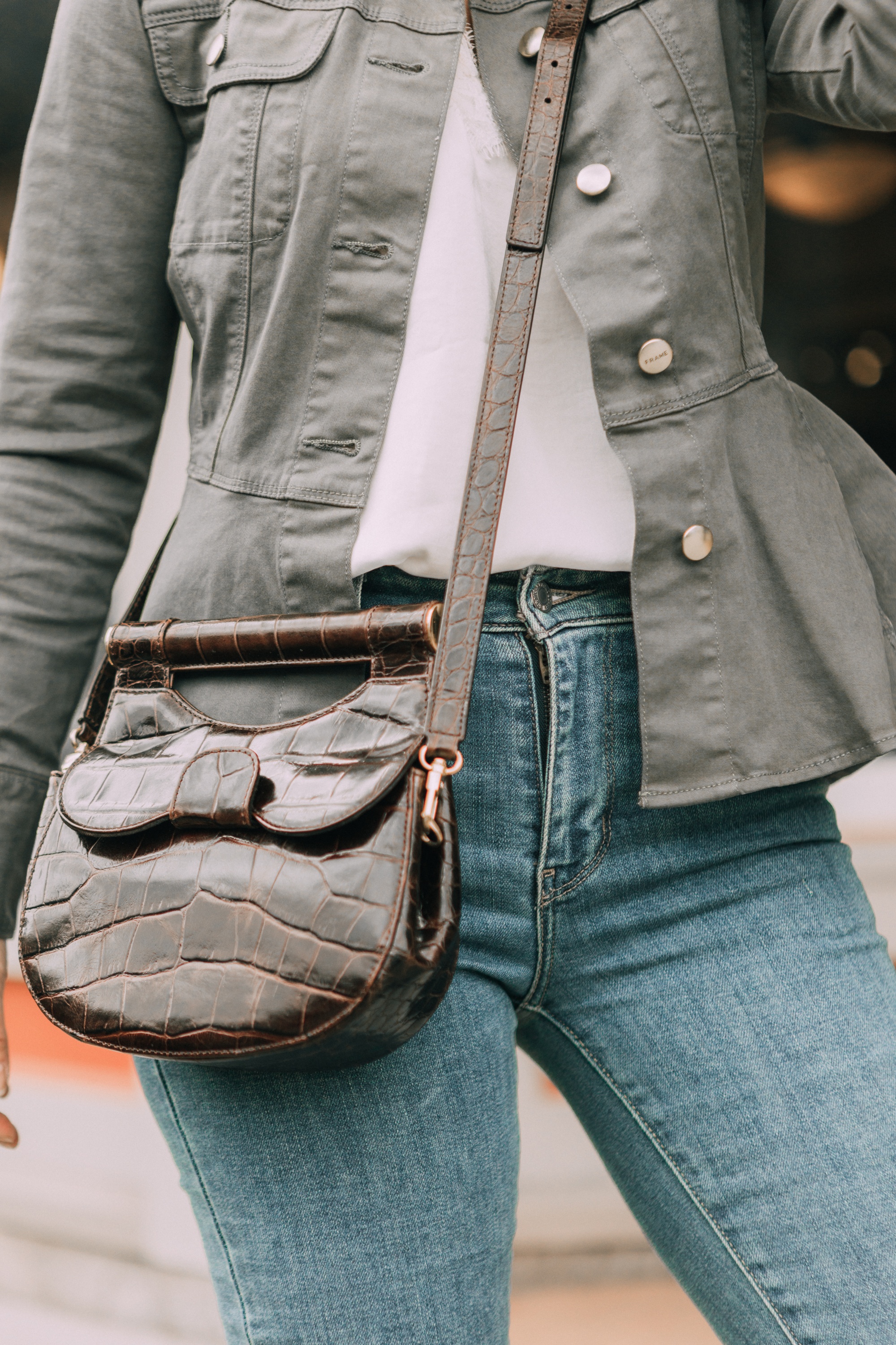 Hot Handbags, Fashion blogger Erin Busbee of BusbeeStyle.com wearing the brown STAUD Madeline Croc-Embossed Crossbody Bag with Levi jeans, white cami, and Frame peplum hem green jacket in Telluride, Colorado
