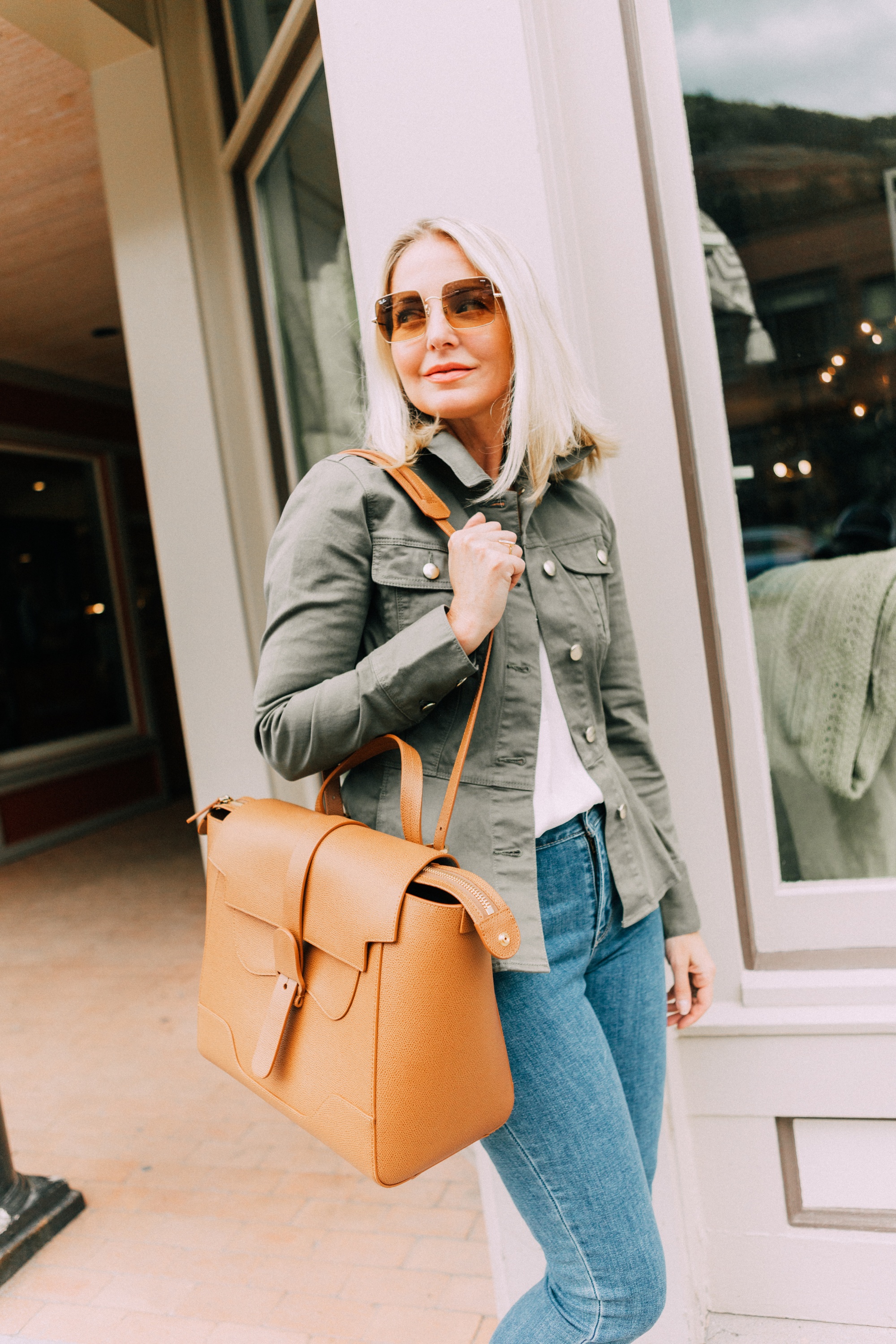 Hot Handbags, Fashion blogger Erin Busbee of BusbeeStyle.com wearing the brown Senreve Maestra Bag with Levi jeans, white cami, and Frame peplum hem green jacket in Telluride, Colorado