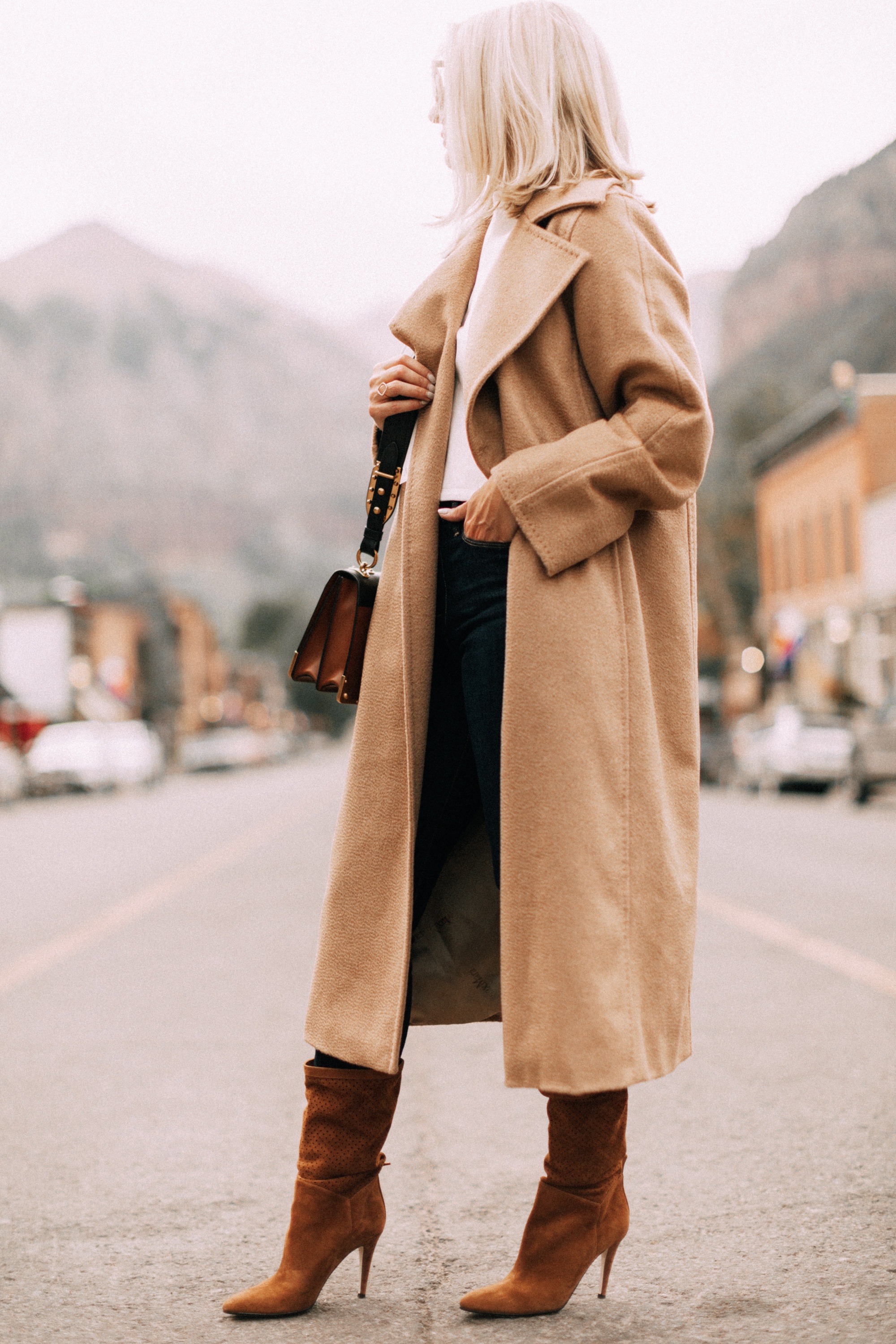 fashion blogger wearing max mara camel coat paired with dark wash skinny jeans brown suede boots 