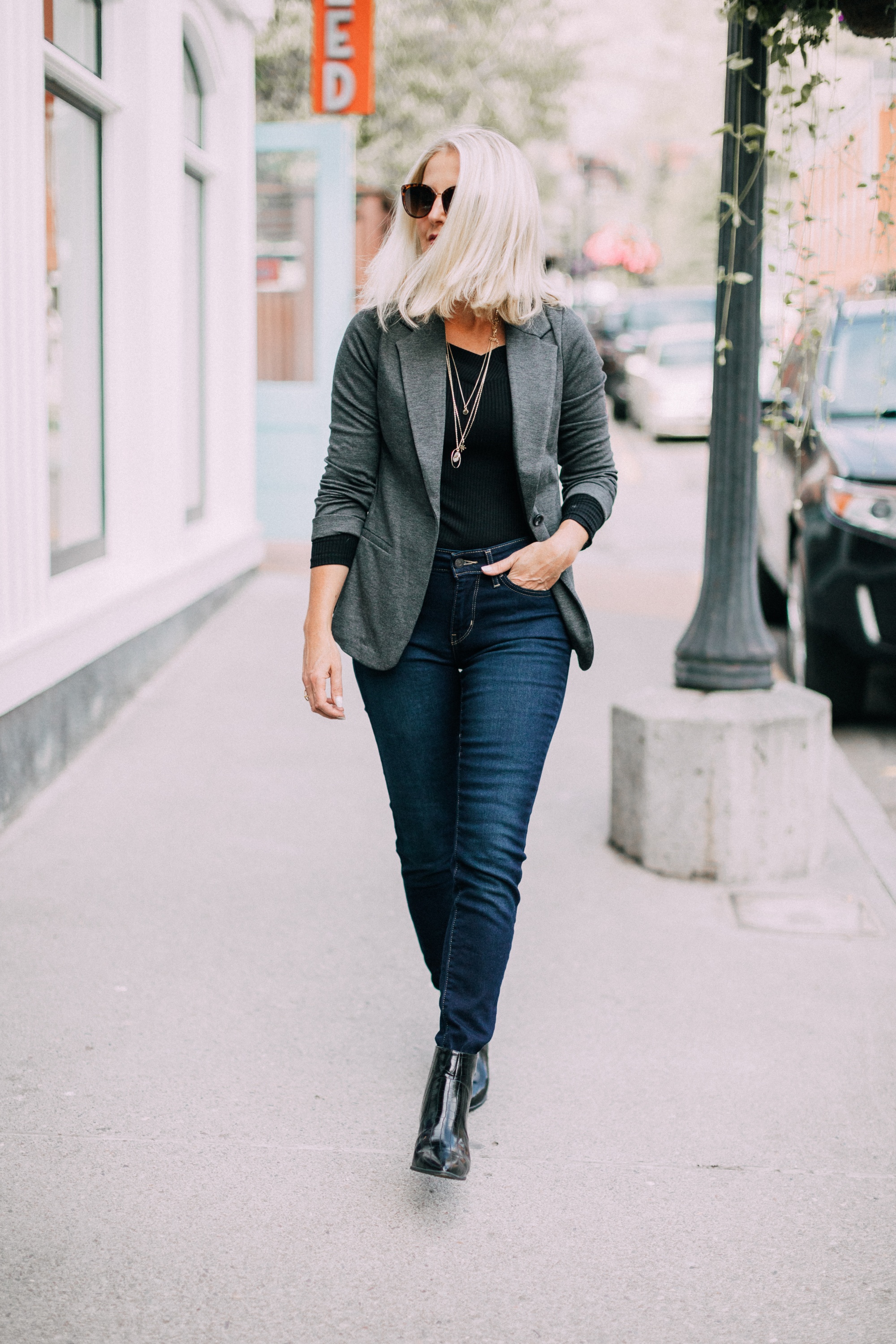 How to layer necklaces, Fashion blogger Erin Busbee of BusbeeStyle.com wearing Levi jeans, black booties, black off the shoulder top, and gray knit blazer from JCPenney with a pre-layered necklace in Telluride, CO