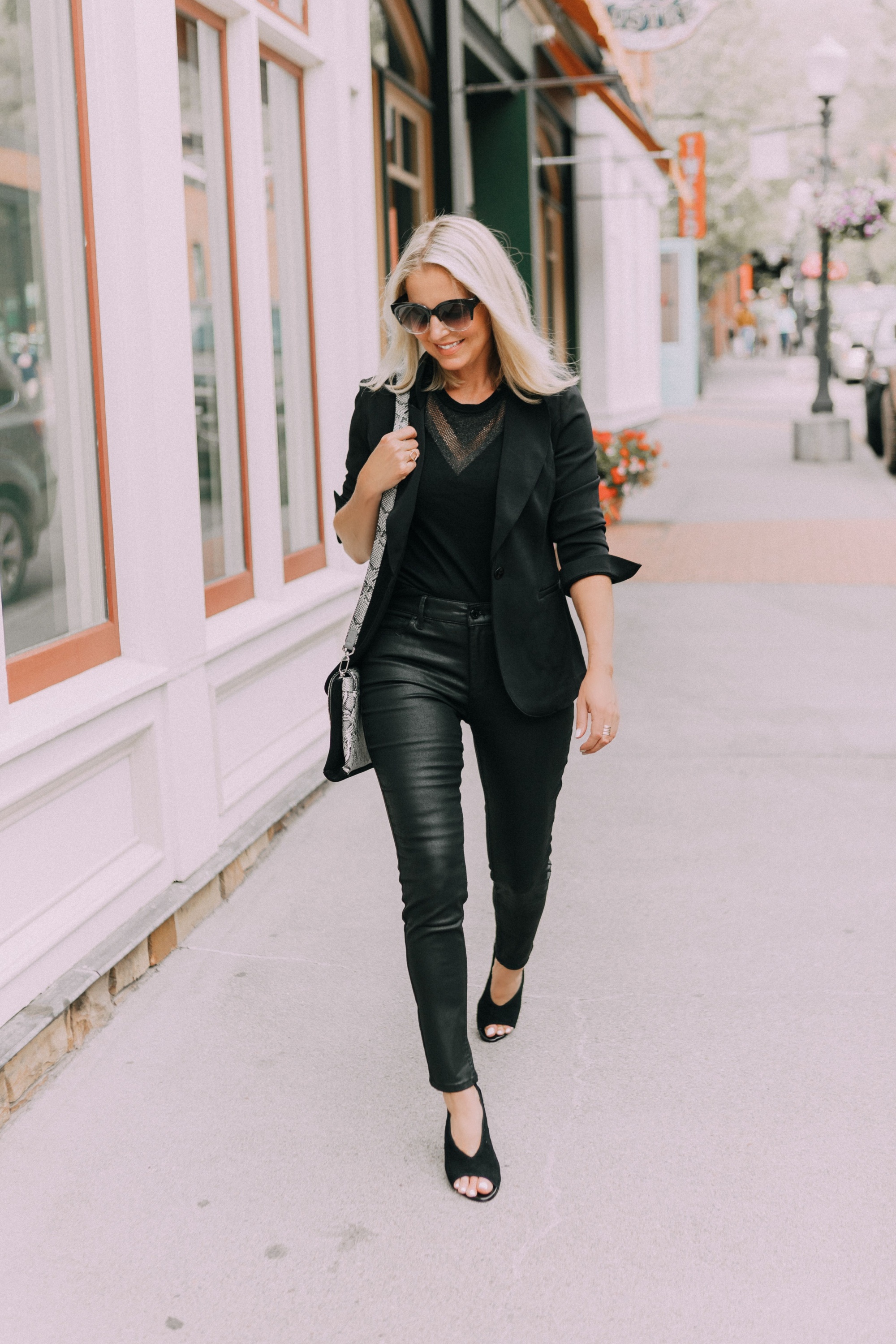 Coated Jeans in petite sizes, Fashion blogger Erin Busbee of BusbeeStyle.com wearing a head to toe all-black look by White House Black Market including coated jeans, python accented bag and heels, sleeveless sweater, and black blazer in Telluride, CO, sharing monochromatic outfits