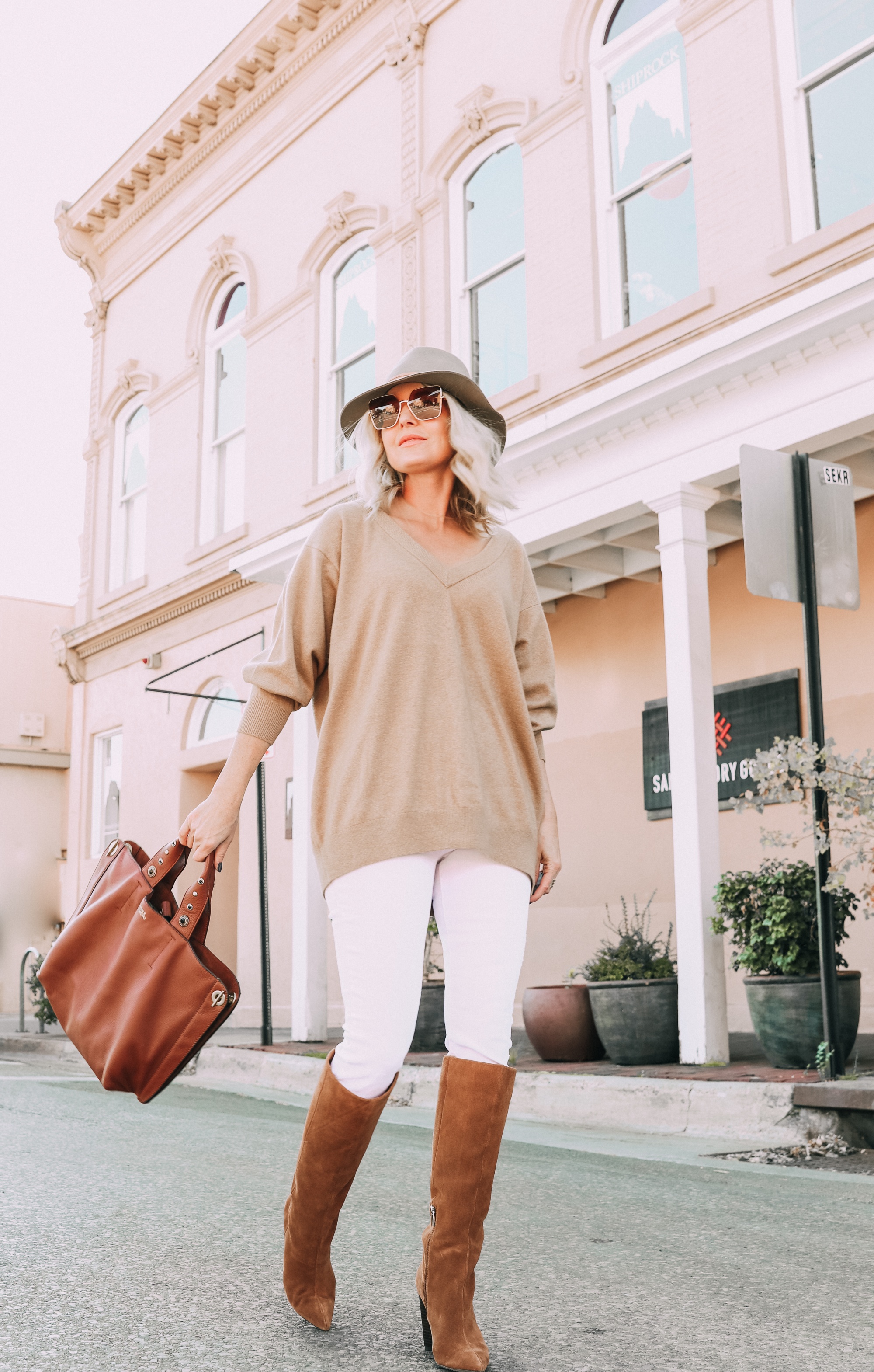Brown Accessories For Fall, Fashion blogger Erin Busbee of BusbeeStyle.com wearing brown boots and brown tote from Vince Camuto with white jeans, camel sweater, leopard scarf, and Rag & bone hat in Santa Fe, New Mexico