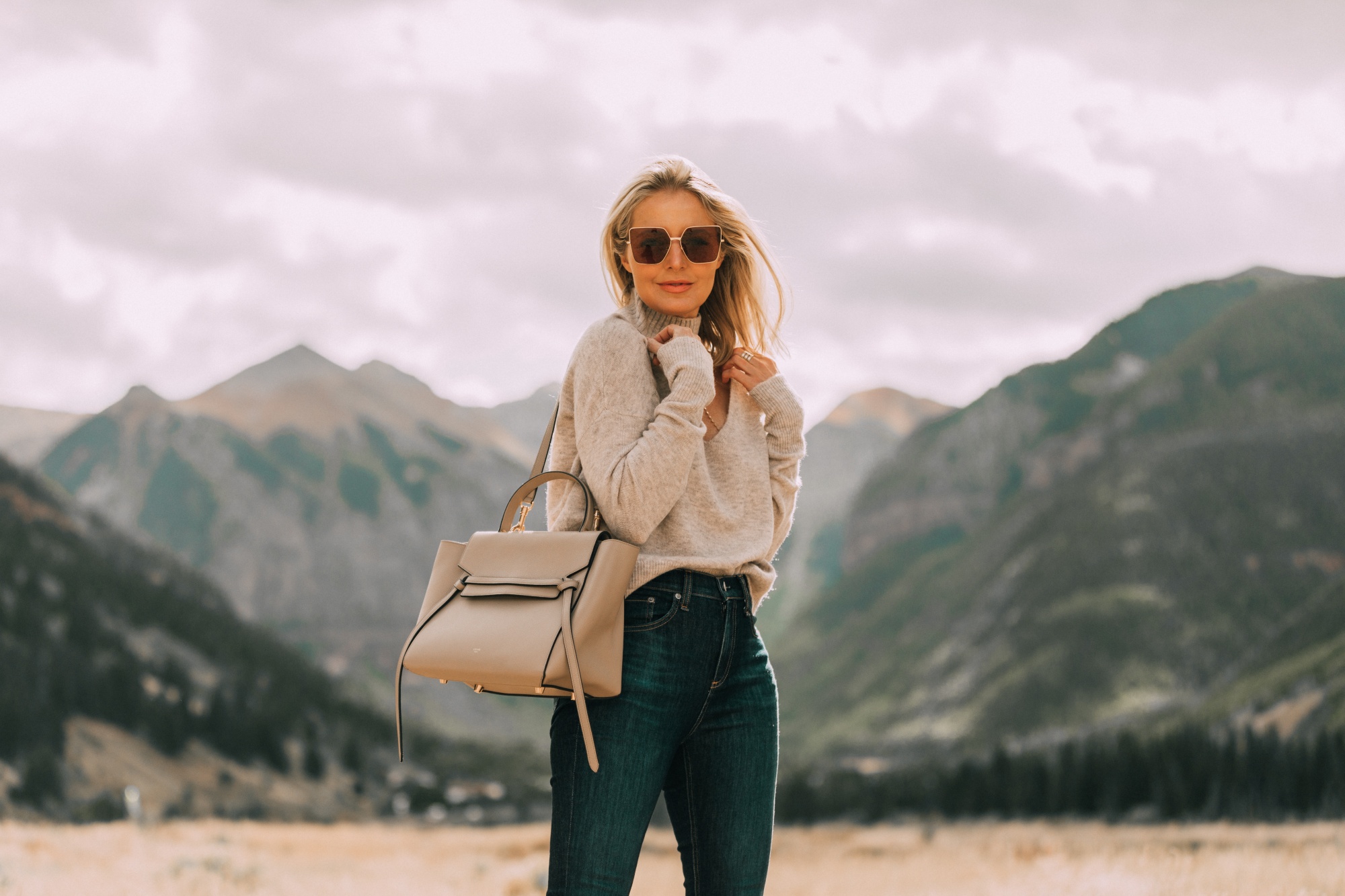 Designer Handbags For Fall, Fashion blogger Erin Busbee of BusbeeStyle.com carrying the Celine belt bag wearing jeans and a sweater in Telluride, CO