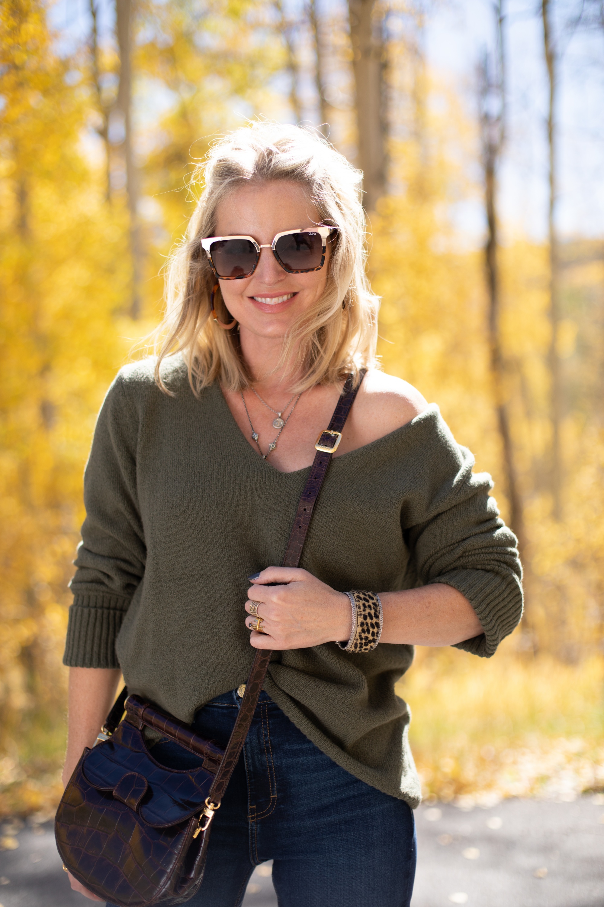 Shoes For Busy Women, Fashion blogger Erin Busbee of BusbeeStyle.com wearing Linea Paolo Wisteria Buckle Wedge Sandals with rag & bone skinny jeans, Something Navy green sweater, Staud Madeline Croc Embossed crossbody, and Quay sunglasses in Telluride, CO