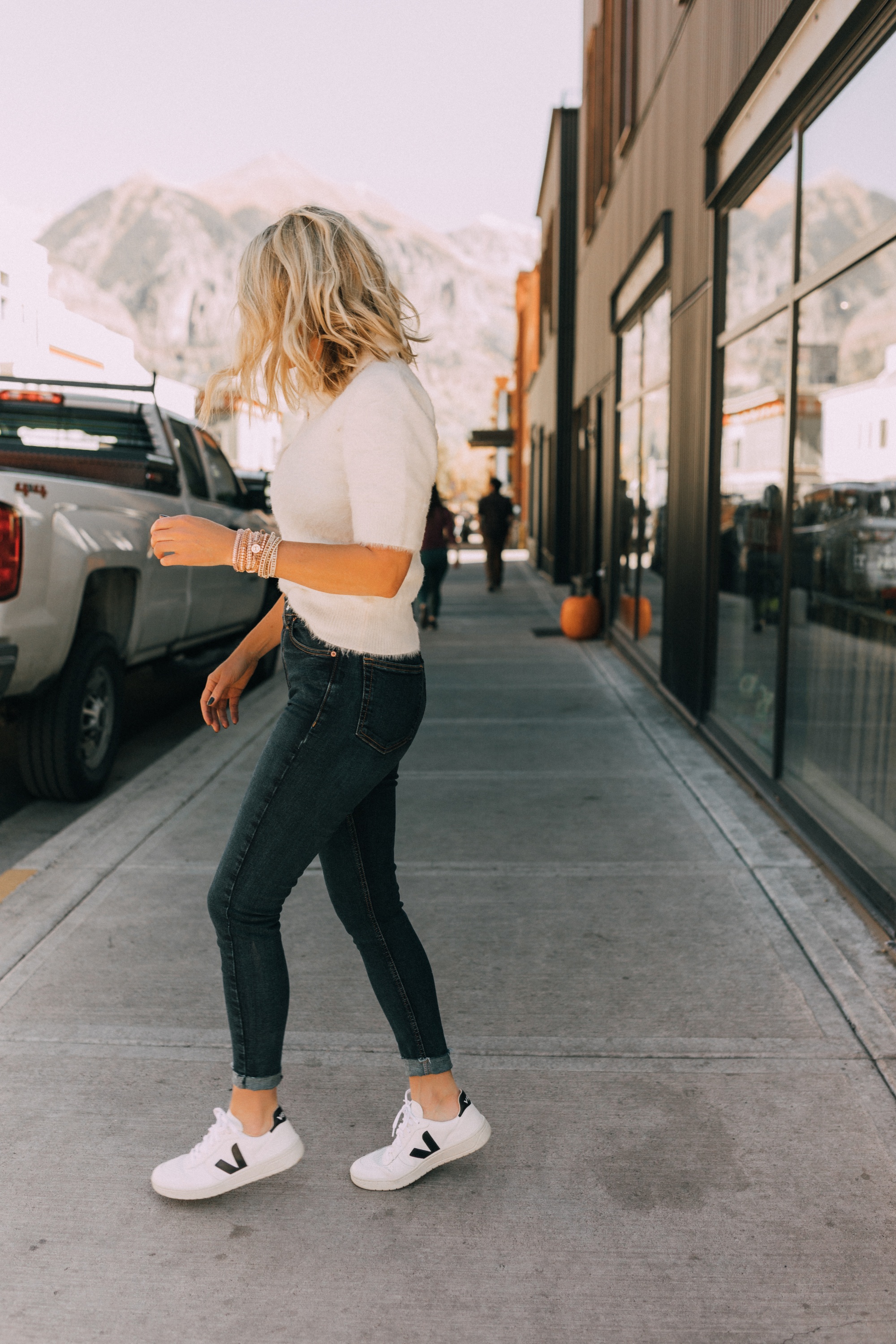 Fall Jewelry, Fashion blogger Erin Busbee of BusbeeStyle.com wearing three wrap bracelets by Victoria Emerson with dark wash skinny jeans, white fuzzy polo sweater, and Veja sneakers in Telluride, CO