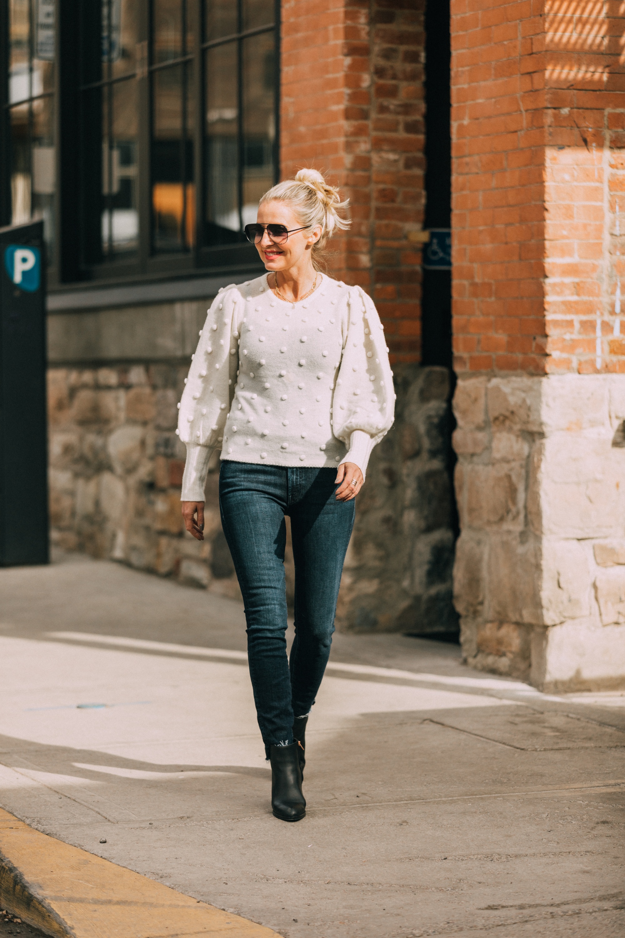 Cashmere Gifts Guide, Fashion blogger Erin Busbee of BusbeeStyle.com wearing a white balloon sleeve pom pom sweater by AQUA Cashmere with dark wash skinny jeans by rag & bone with black cutout rose gold booties by Alexander Wang from Bloomingdale's in Telluride, CO