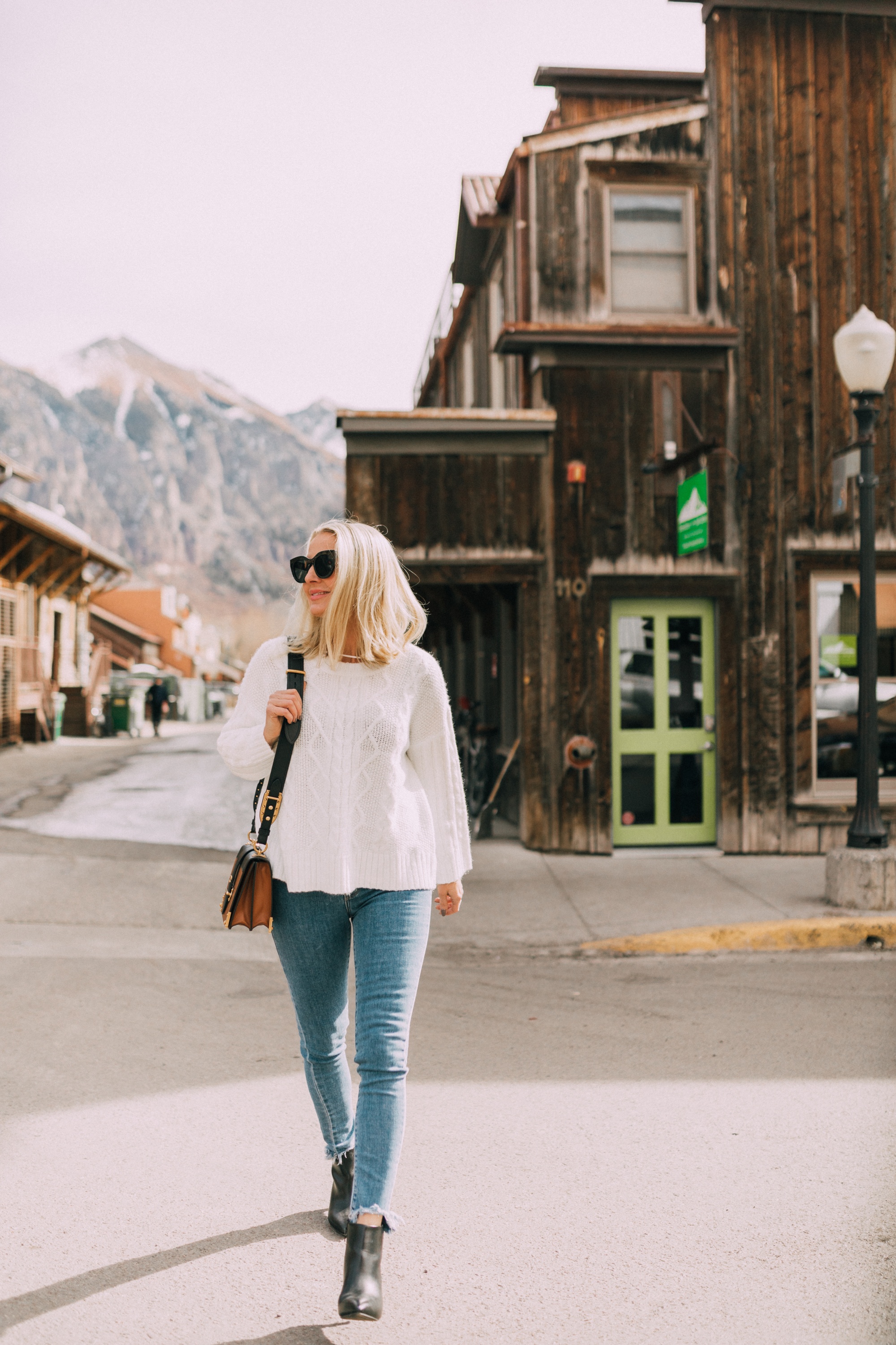 Affordable Sweaters, fashion blogger Erin Busbee of BusbeeStyle.com wearing a white cable knit sweater, Levi's jeans, and black heeled booties from JCPenney in Telluride, CO