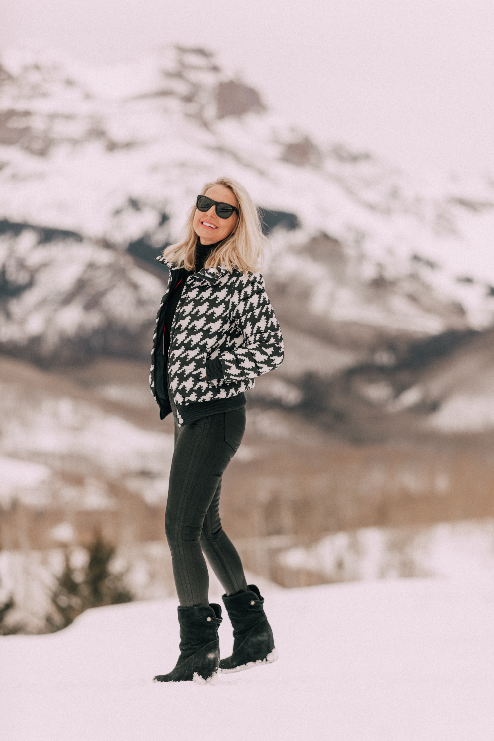 Chic Ski Brand, Fashion blogger Erin Busbee of BusbeeStyle.com wearing black Rocket leatherette Skinny Jeans by Citizens of Humanity with a black cashmere turtleneck sweater by Aqua, and a houndstooth puffer jacket by Perfect Moment from Shopbop, and Ugg wedge boots in the snow in Telluride, CO