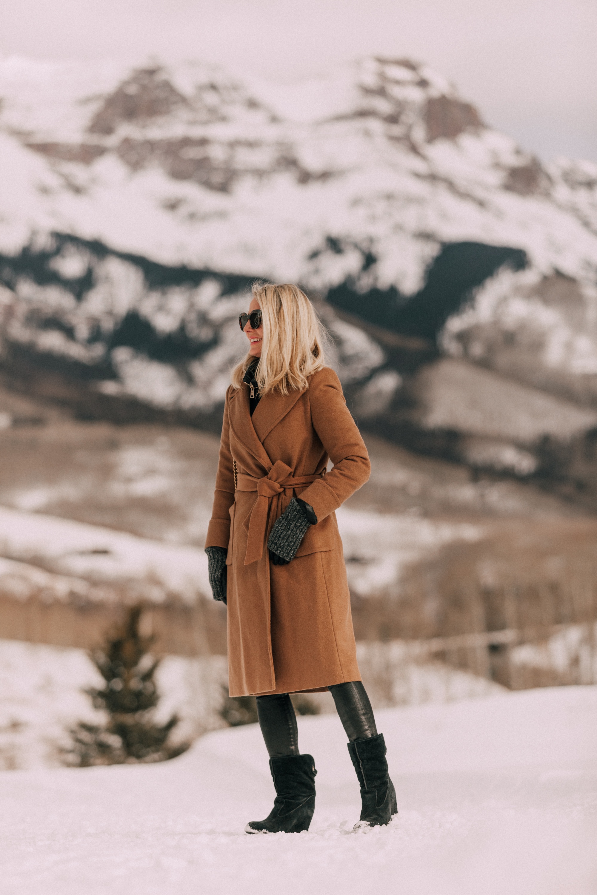 How To Layer Your Clothes, Fashion blogger Erin Busbee of BusbeeStyle.com wearing a black turtleneck sweater with Citizens of Humanity Rocket leatherette skinny jeans, Ugg wedge boots, camel wool coat by Mackage, and Herno puffer coat in Telluride, CO