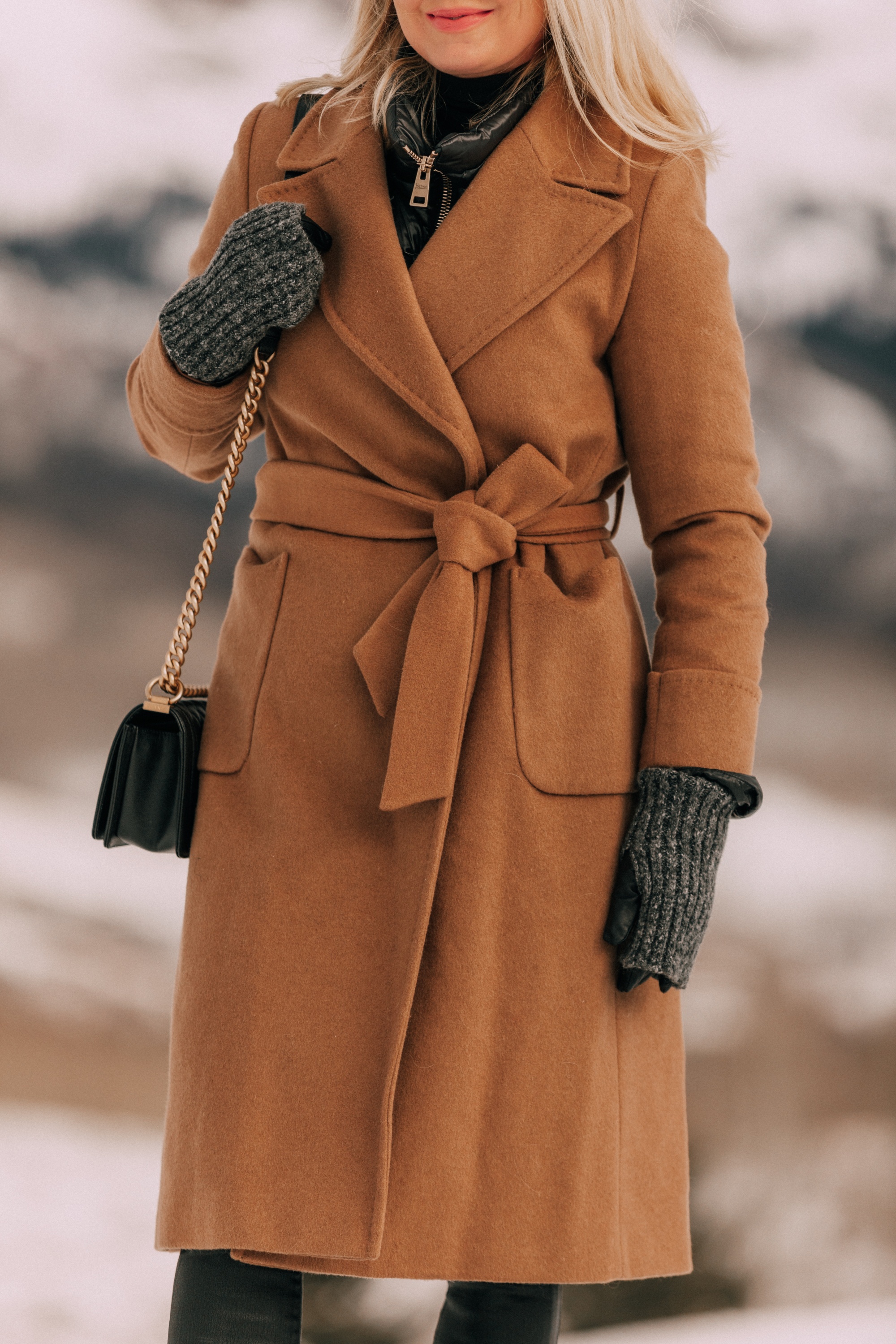 How To Layer Your Clothes, Fashion blogger Erin Busbee of BusbeeStyle.com wearing a black turtleneck sweater with Citizens of Humanity Rocket leatherette skinny jeans, Ugg wedge boots, camel wool coat by Mackage, Herno puffer coat, Carolina Amato gloves, Chanel boy bag in Telluride, CO