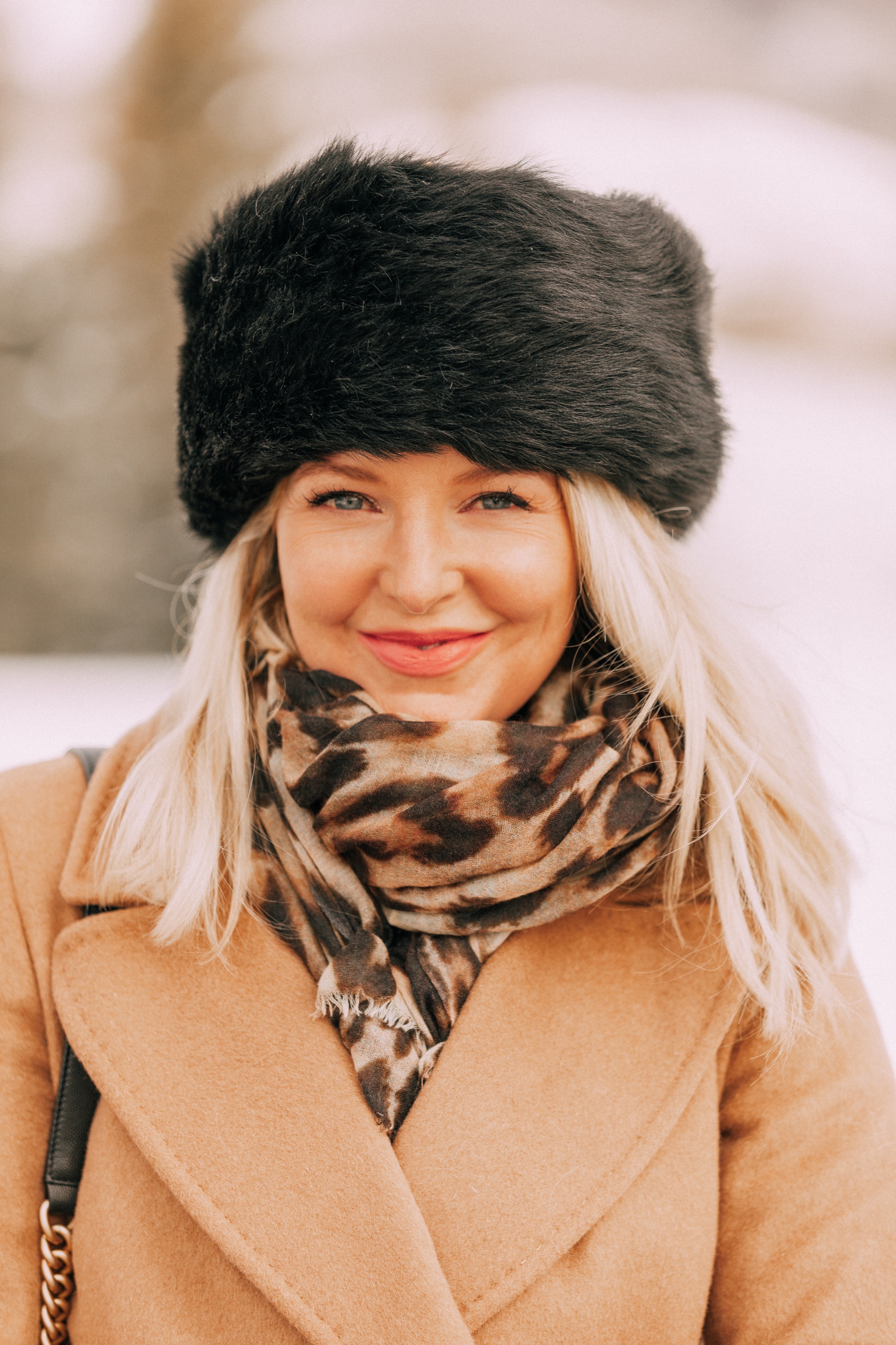 how to layer winter clothes to stay warm and look stylish, cold weather outfit accessories leopard scarf black fur hat camel wool Mackage coat