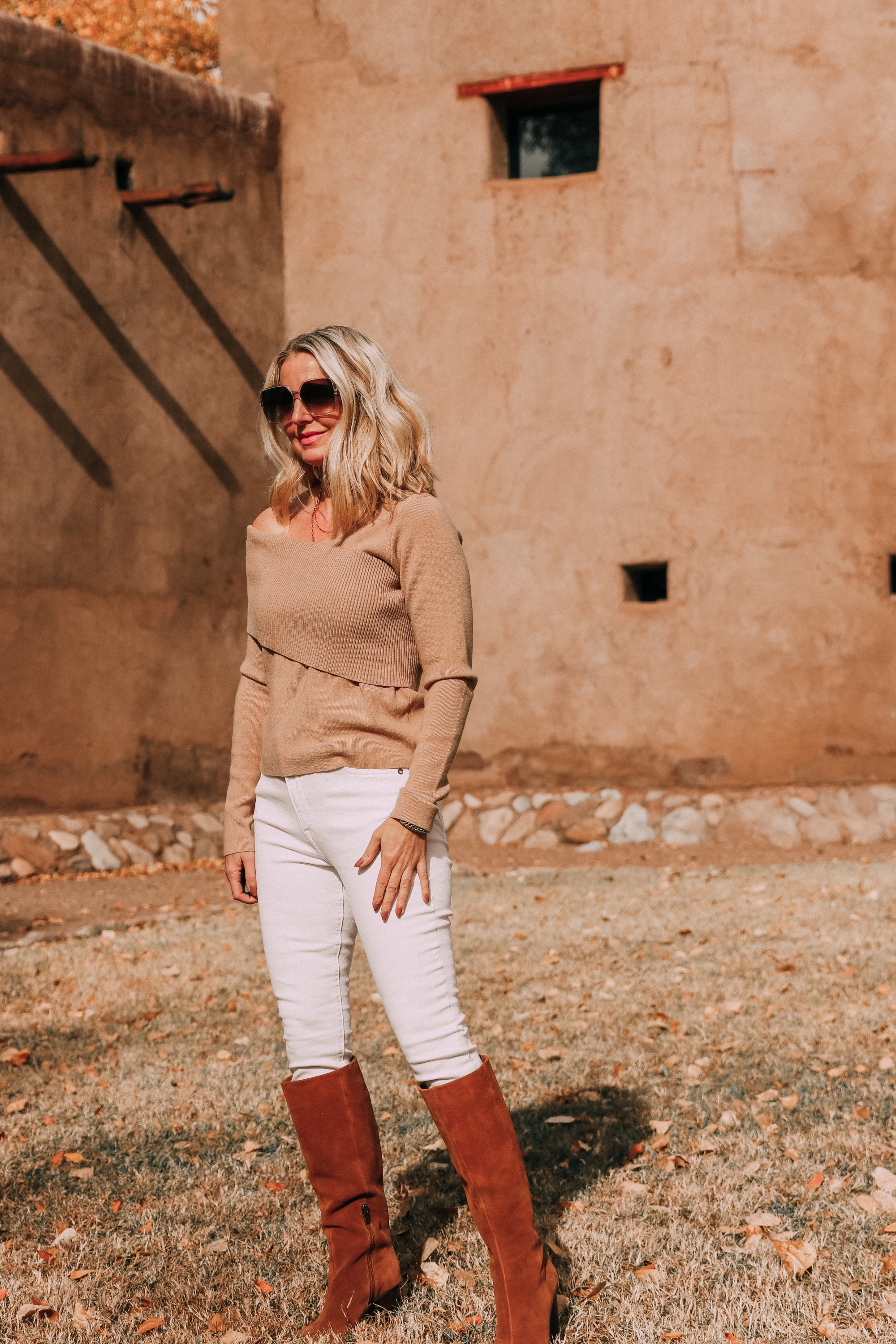 everyday outfits worn by fashion blogger including camel off the shoulder sweater white jeans brown suede cone heel boots