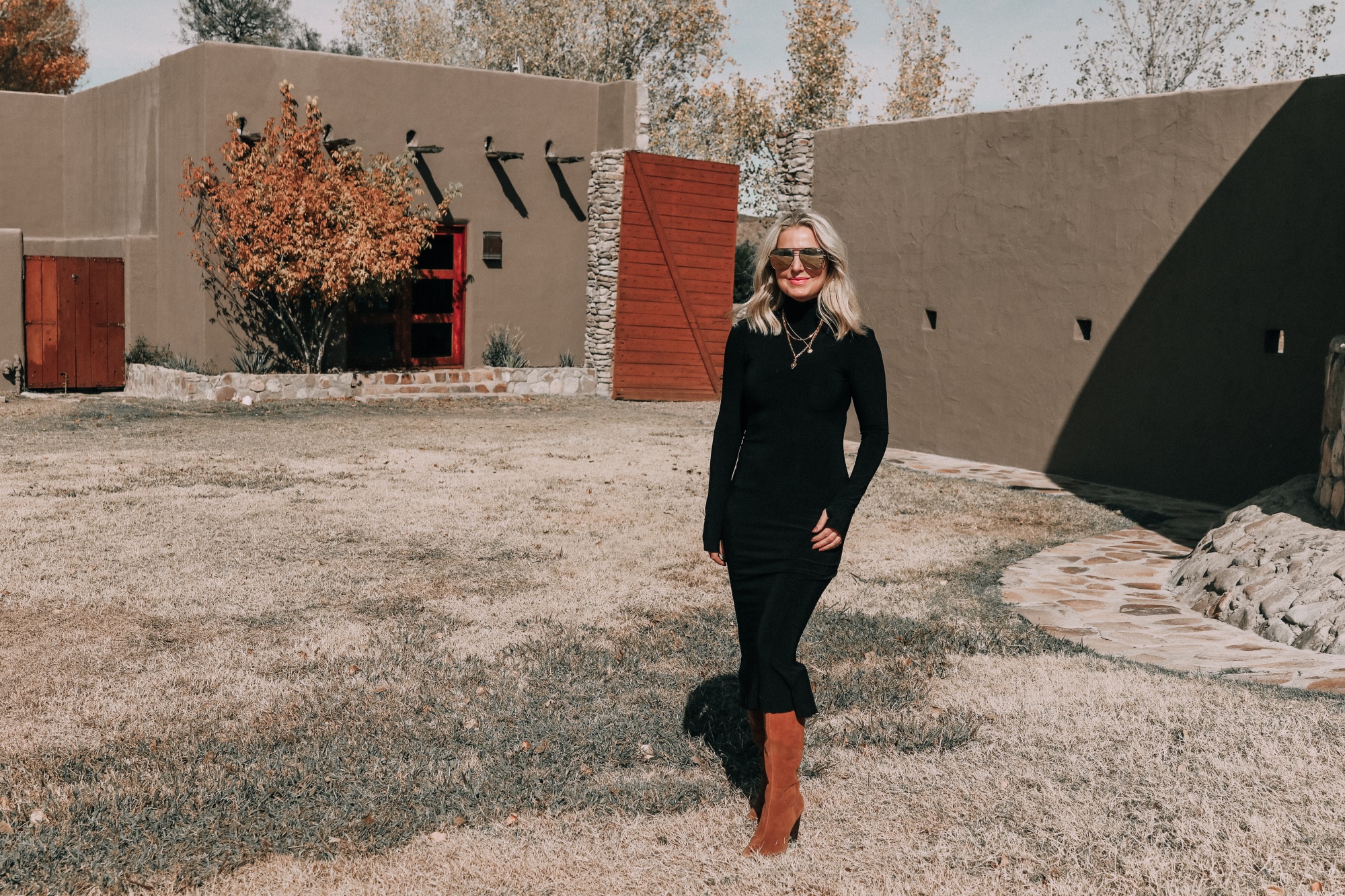 fashion blogger erin busbee wearing black turtleneck midi dress with brown suede knee high boots