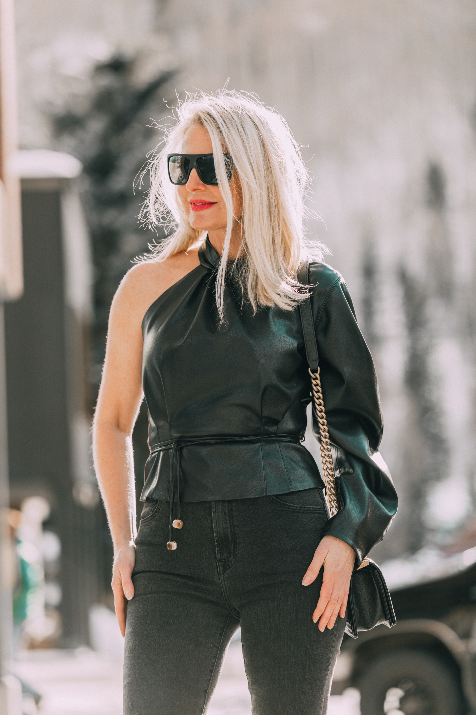 Date Night Outfits, Fashion blogger Erin Busbee of BusbeeStyle.com wearing black minimally distressed jeans, Jimmy Choo pumps, and faux leather one shoulder top by Nanushka in Telluride, Colorado