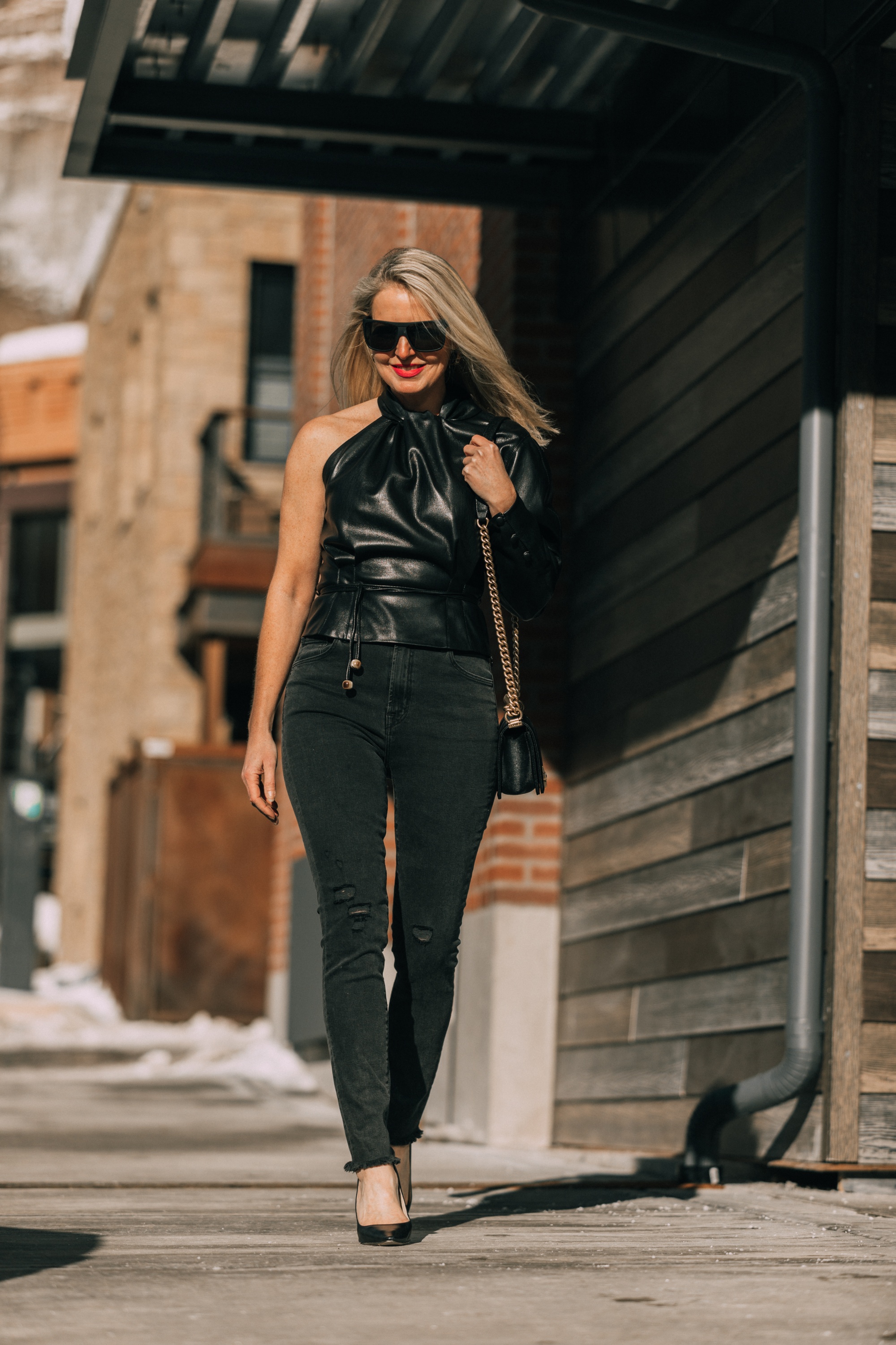 Date Night Outfits, Fashion blogger Erin Busbee of BusbeeStyle.com wearing black minimally distressed jeans, Jimmy Choo pumps, and faux leather one shoulder top by Nanushka in Telluride, Colorado
