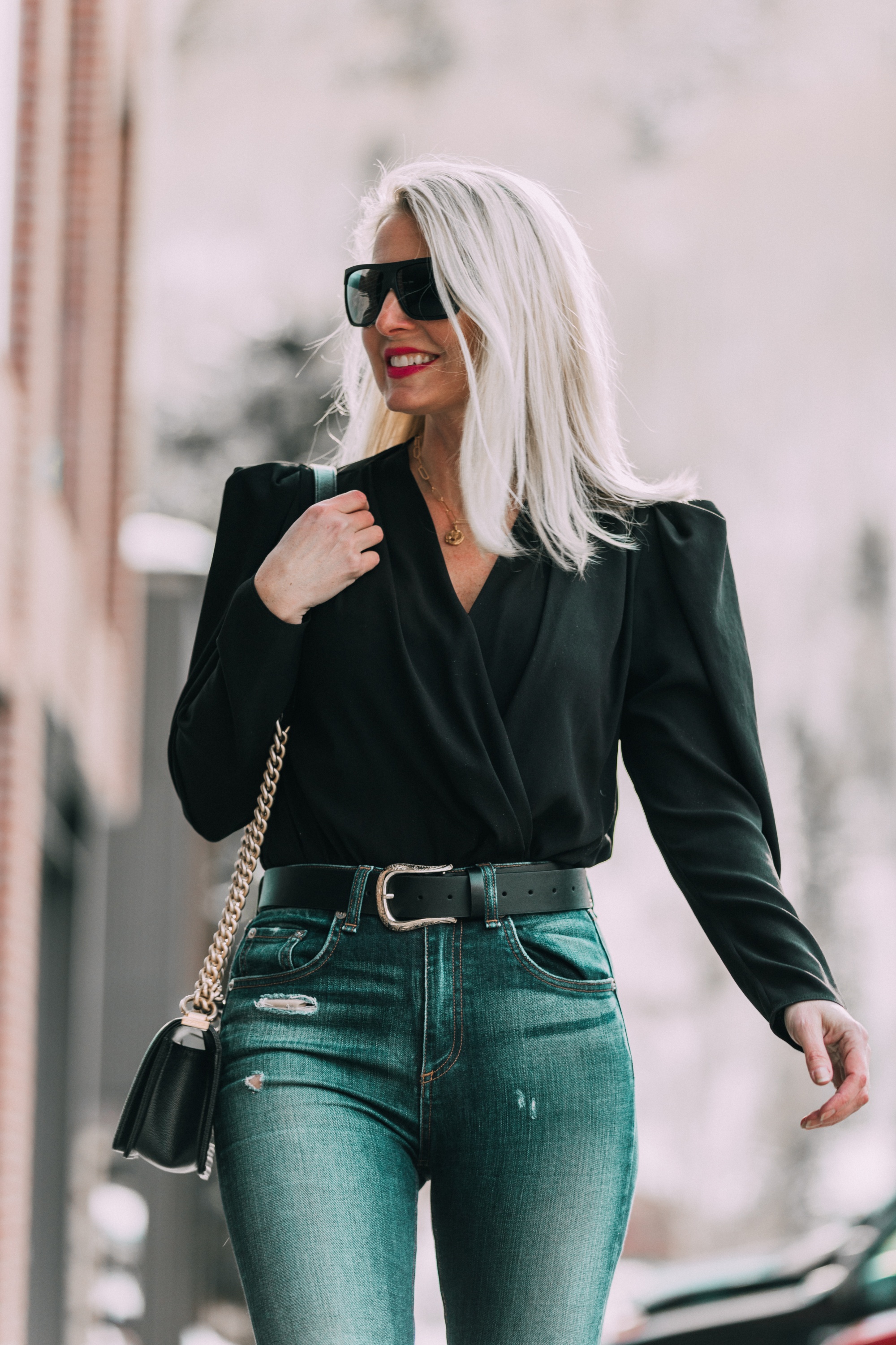 fashion blogger erin busbee of BusbeeStyle.com wearing a black top with statement puff sleeve blouse with quay flat top sunglasses
