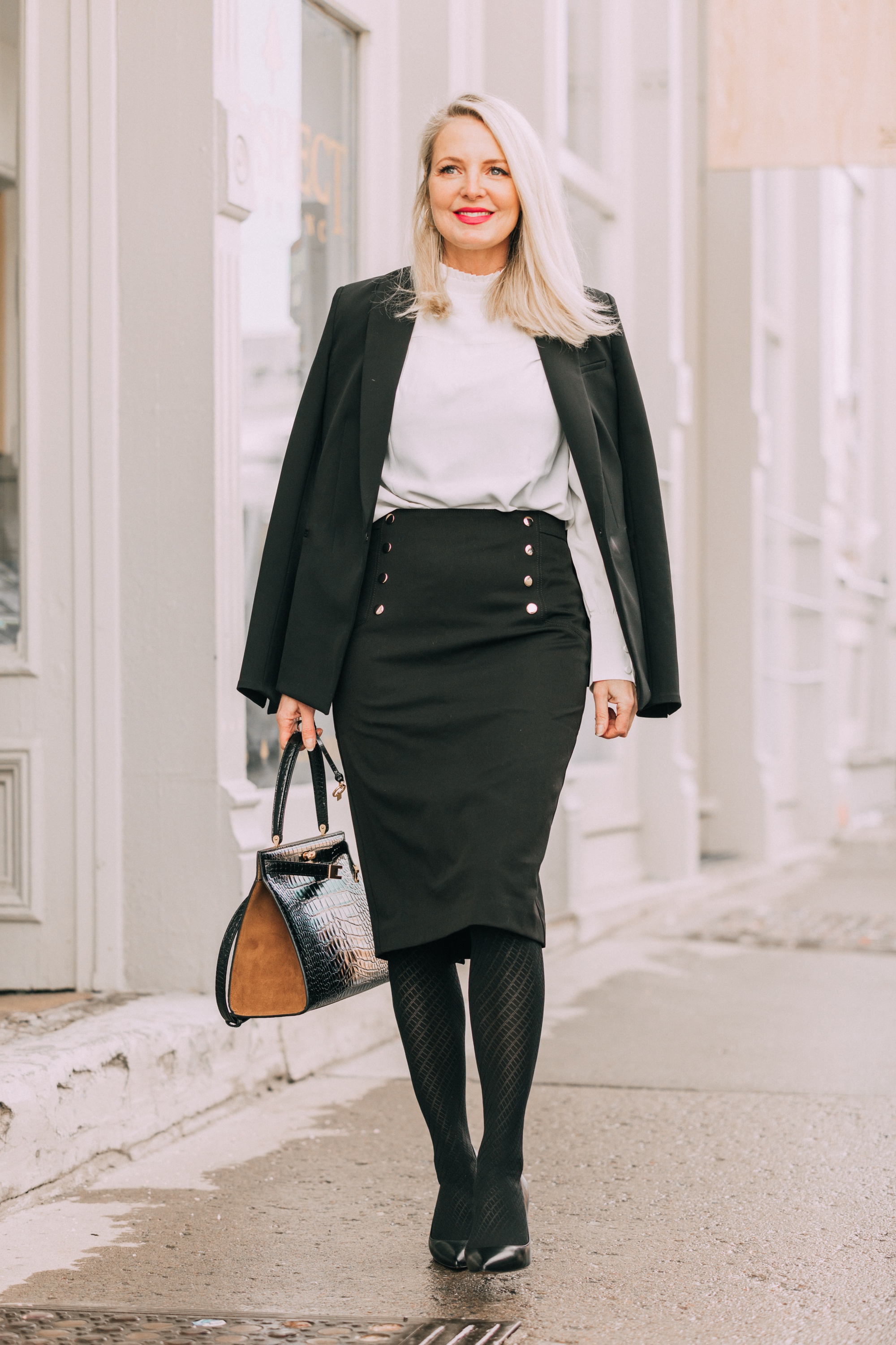 Wardrobe Basics, Fashion blogger Erin Busbee of BusbeeStyle.com sharing wardrobe basics from Ann Taylor wearing a black pencil skirt with sailir buttons, a white ruffle neck blouse, classic black blazer, black tights, and black pumps all from Ann Taylor in Telluride, Colorado