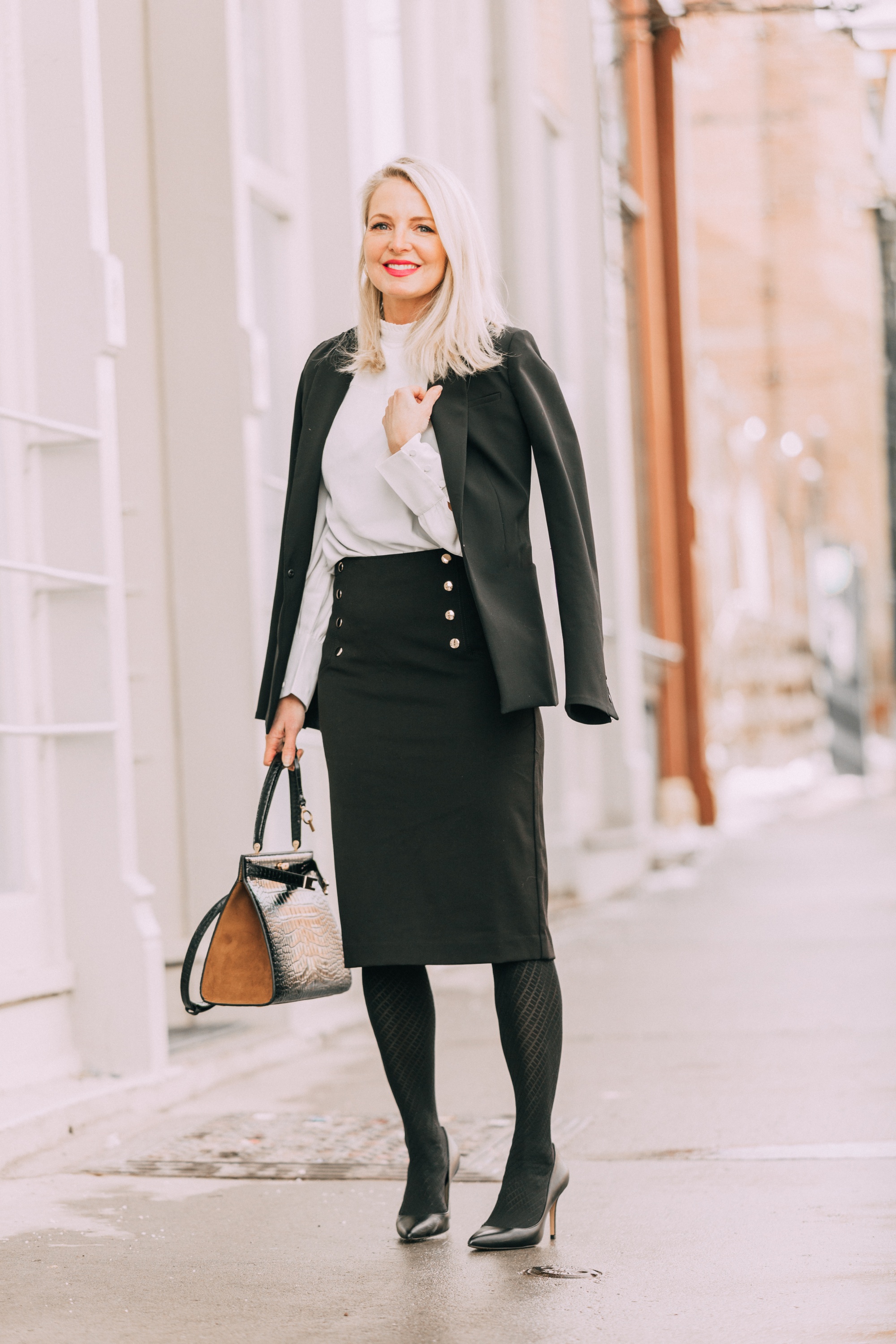 Wardrobe Basics, Fashion Blogger Erin Busbee Of Busbeestyle.com Sharing Wardrobe Basics From Ann Taylor Wearing A Black Pencil Skirt With Sailir Buttons, A White Ruffle Neck Blouse, Classic Black Blazer, Black Tights, And Black Pumps All From Ann Taylor In Telluride, Colorado