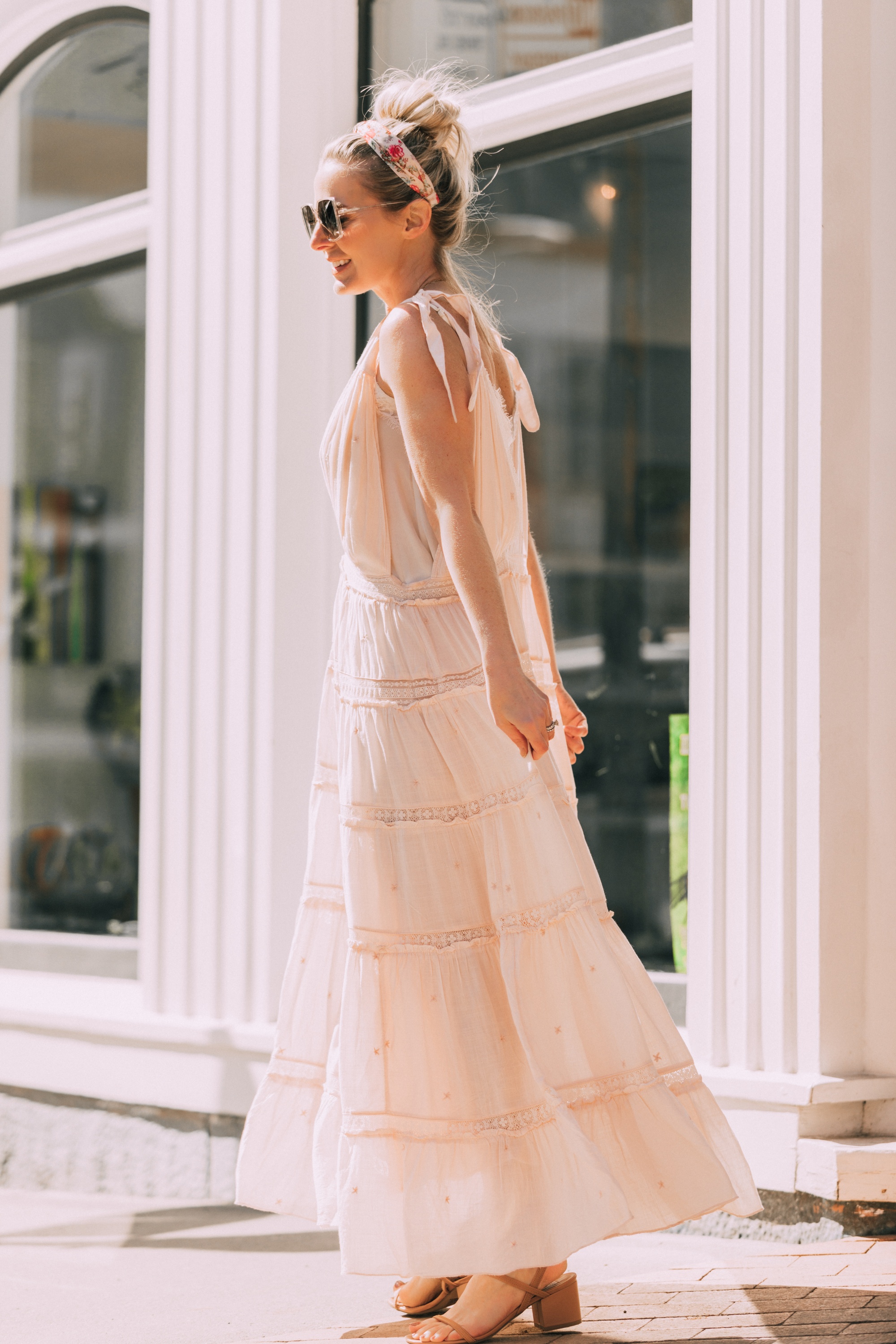 How To Wear A Maxi Dress, Fashion blogger Erin Busbee of BusbeeStyle.com wearing a peach Free People Lily of the Valley Maxi dress with brown block heel sandals, white lace cami underneath, floral headband, gold necklace, and sunglasses walking in Telluride, Colorado