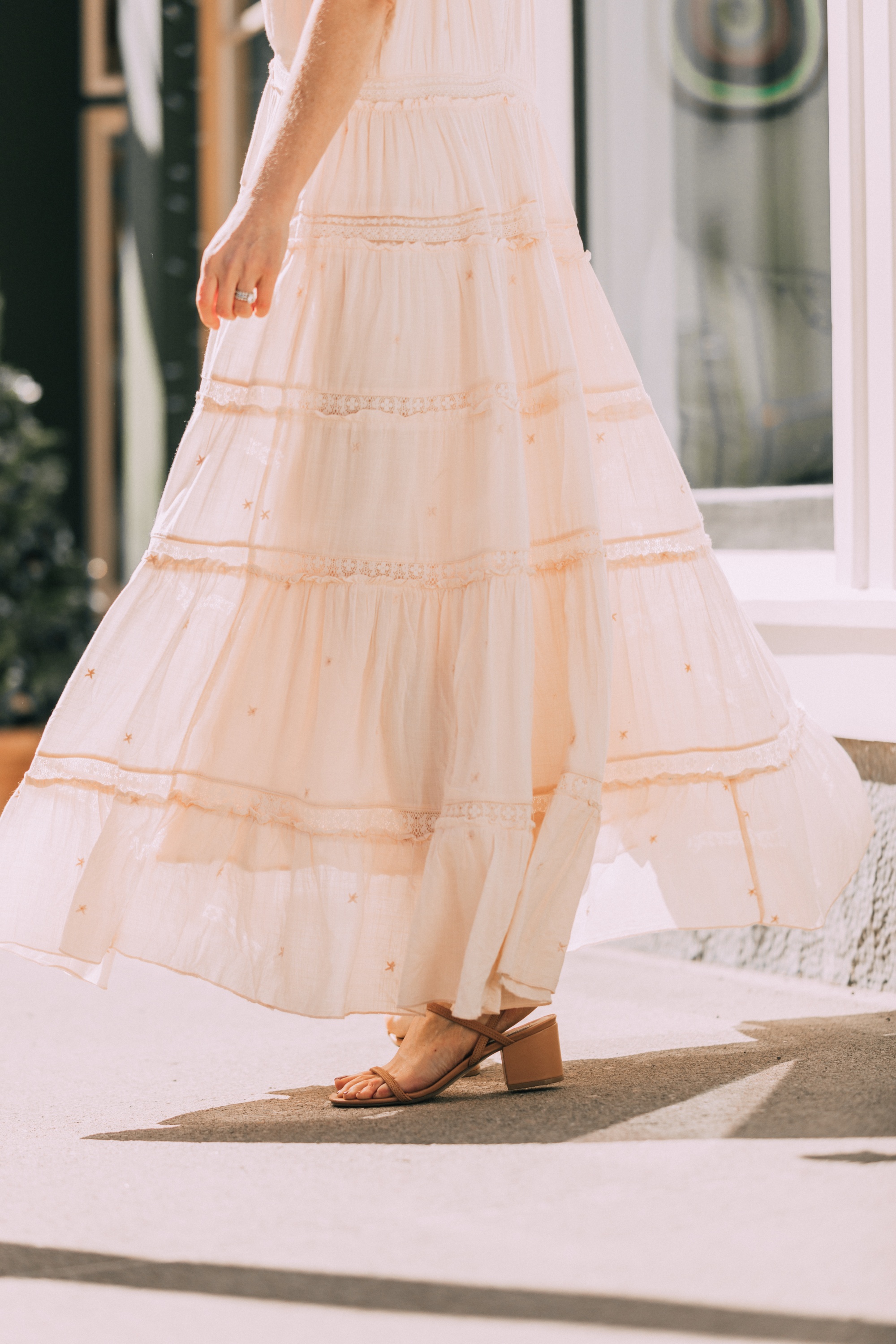 How To Wear A Maxi Dress, Fashion blogger Erin Busbee of BusbeeStyle.com wearing a peach Free People Lily of the Valley Maxi dress with brown block heel sandals, white lace cami underneath, floral headband, gold necklace, and sunglasses walking in Telluride, Colorado