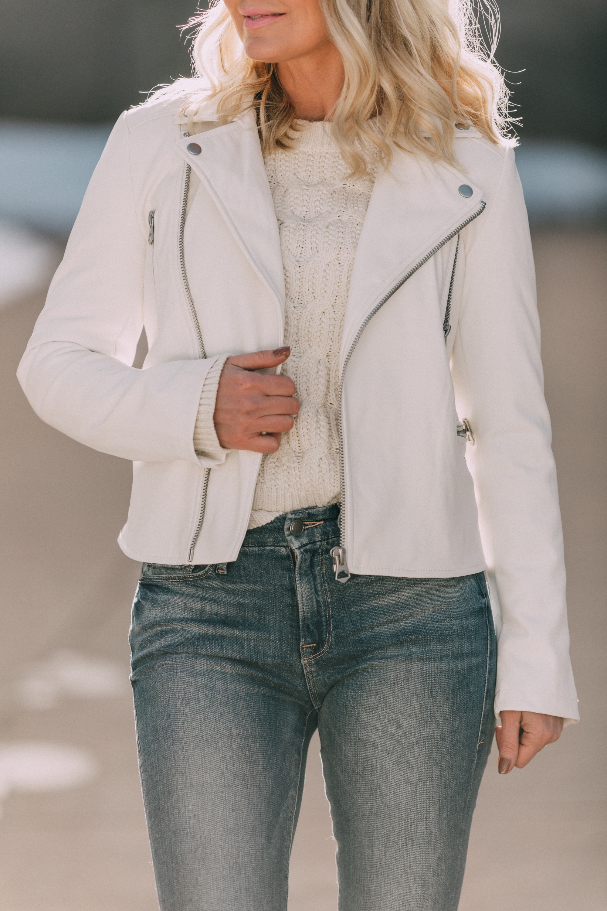 walmart scoop fashion blogger wearing white faux leather moto jacket, white cable knit sweater and medium wash skinny jeans in Telluride, Colorado