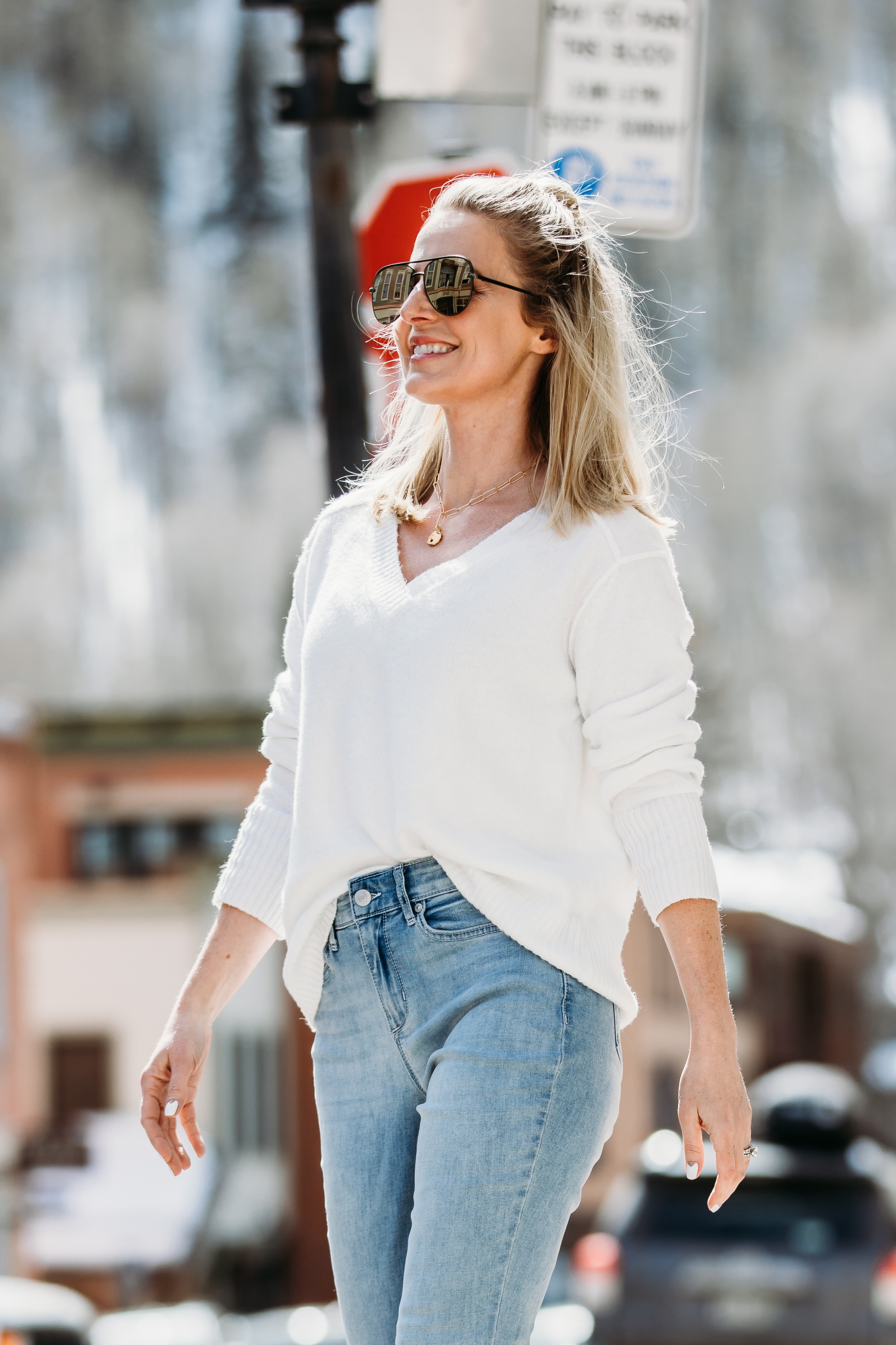 White Sweaters, Fashion blogger Erin Busbee of BusbeeStyle.com wearing a white v-neck sweater by Scoop, light wash skinny jeans by Sofia Vergara, brown suede booties, and green mirrored QUAY sunglasses from Walmart walking in Telluride, Colorado
