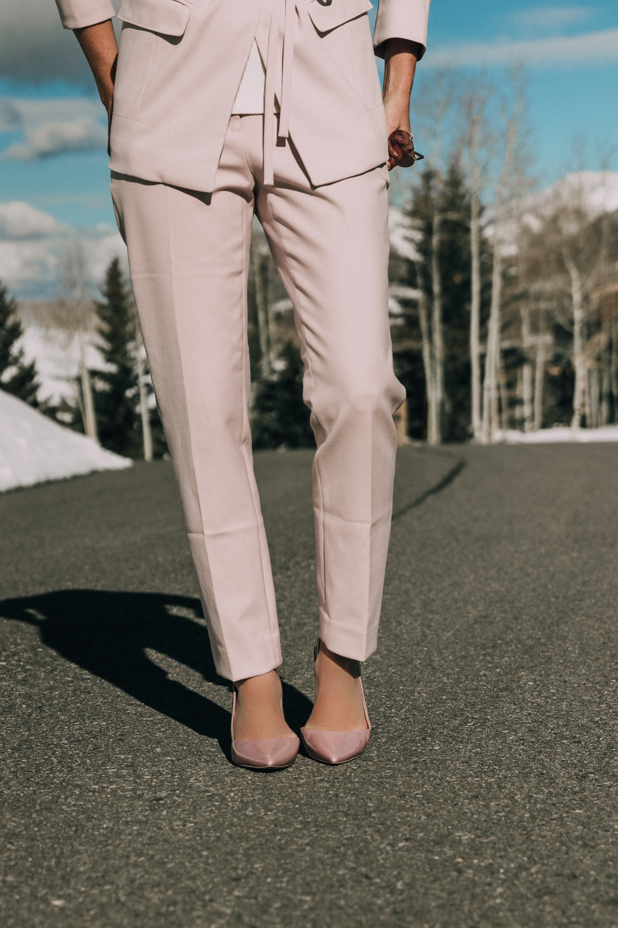 Pink Office Outfit, Fashion blogger Erin Busbee of BusbeeStyle.com wearing a pink power suit from White House Black Market, including a pink belted blazer, pink soft stretch pants, white puff sleeve sweater dress, pink pumps, pink earrings, and aviator sunglasses in Telluride, Colorado