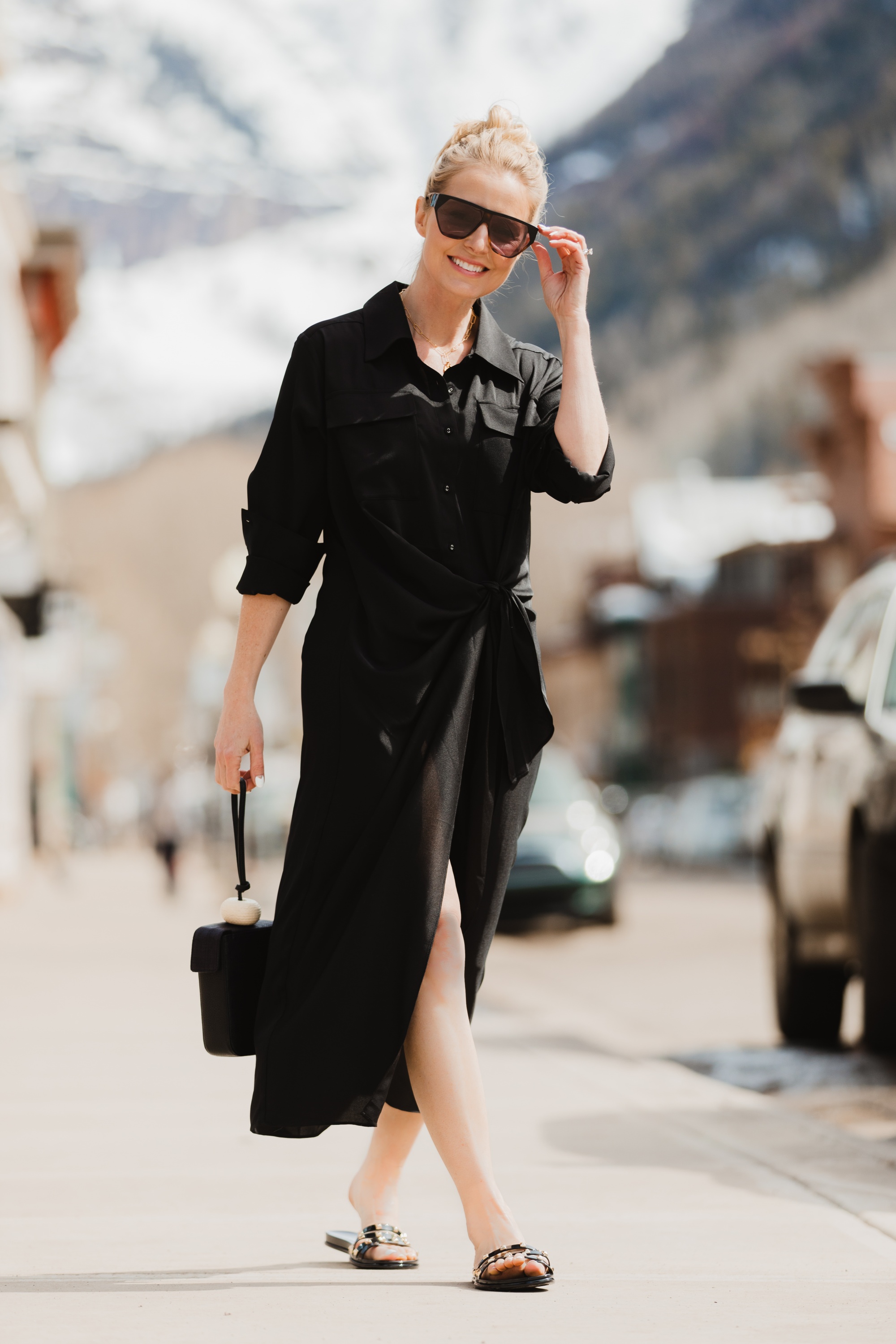 Spring Accessories, Fashion blogger Erin Busbee of BusbeeStyle.com wearing a black L'Academie shirt dress with black studded strappy slides and black bracelet bag from Vince Camuto in Telluride, Colorado