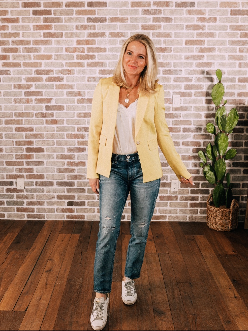 Stylish Work From Home Outfits, Fashion blogger Erin Busbee of BusbeeStyle.com wearing a yellow blazer by Veronica Beard with white cami, Moussy Vintage jeans, and golden goose sneakers in Telluride, Colorado