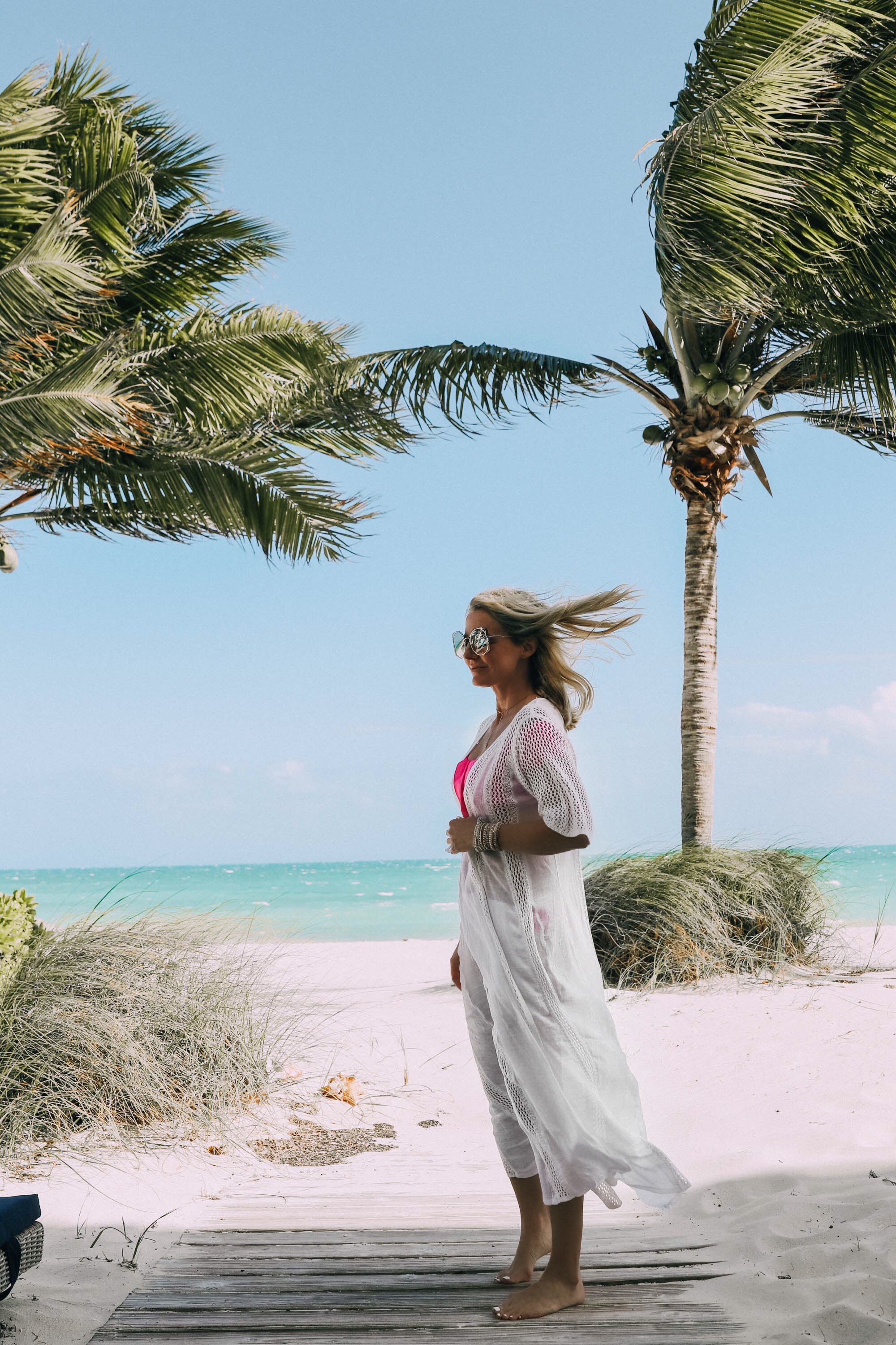 Best Coverups, Fashion blogger Erin Busbee of BusbeeStyle.com wearing a white crochet coverup by Elan over a pink swimsuit in the Bahamas