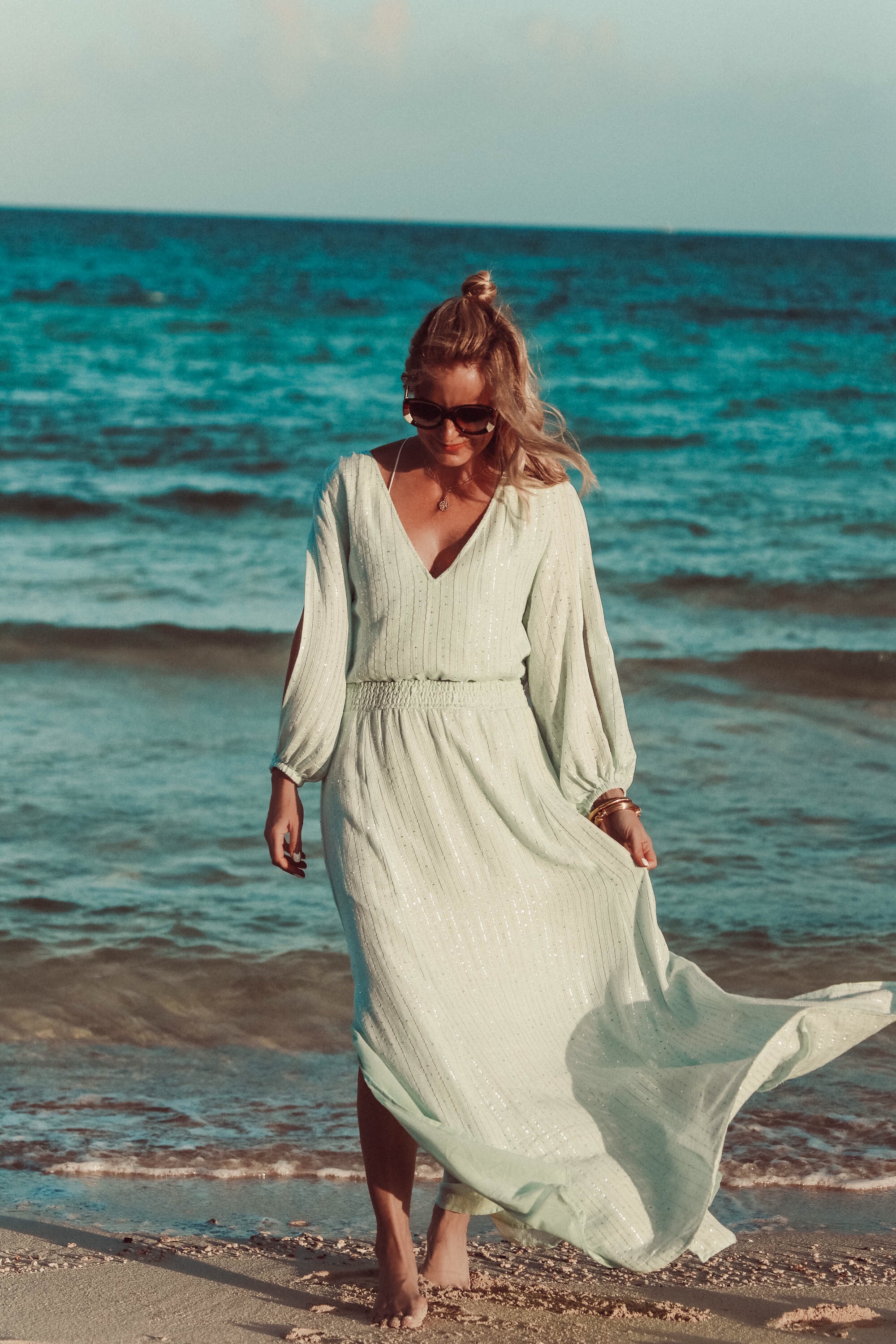 Maxi Dresses For Summer, Fashion blogger Erin Busbee of Busbee Style wearing a blue sequin maxi dress by Sundress, Chloe brown rainbow sunglasses, and Aligheri gold ritual necklace walking on the beach in the Bahamas,