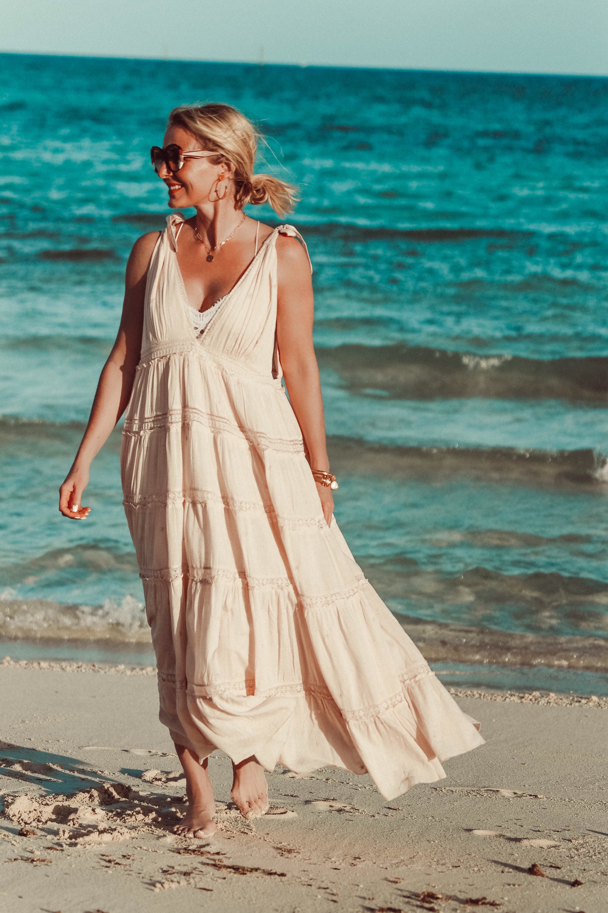 Maxi Dresses For Summer, Fashion blogger Erin Busbee of Busbee Style wearing a peach Free People Lily of the Valley maxi dress with a Free People lace bralette walking on the beach in the Bahamas